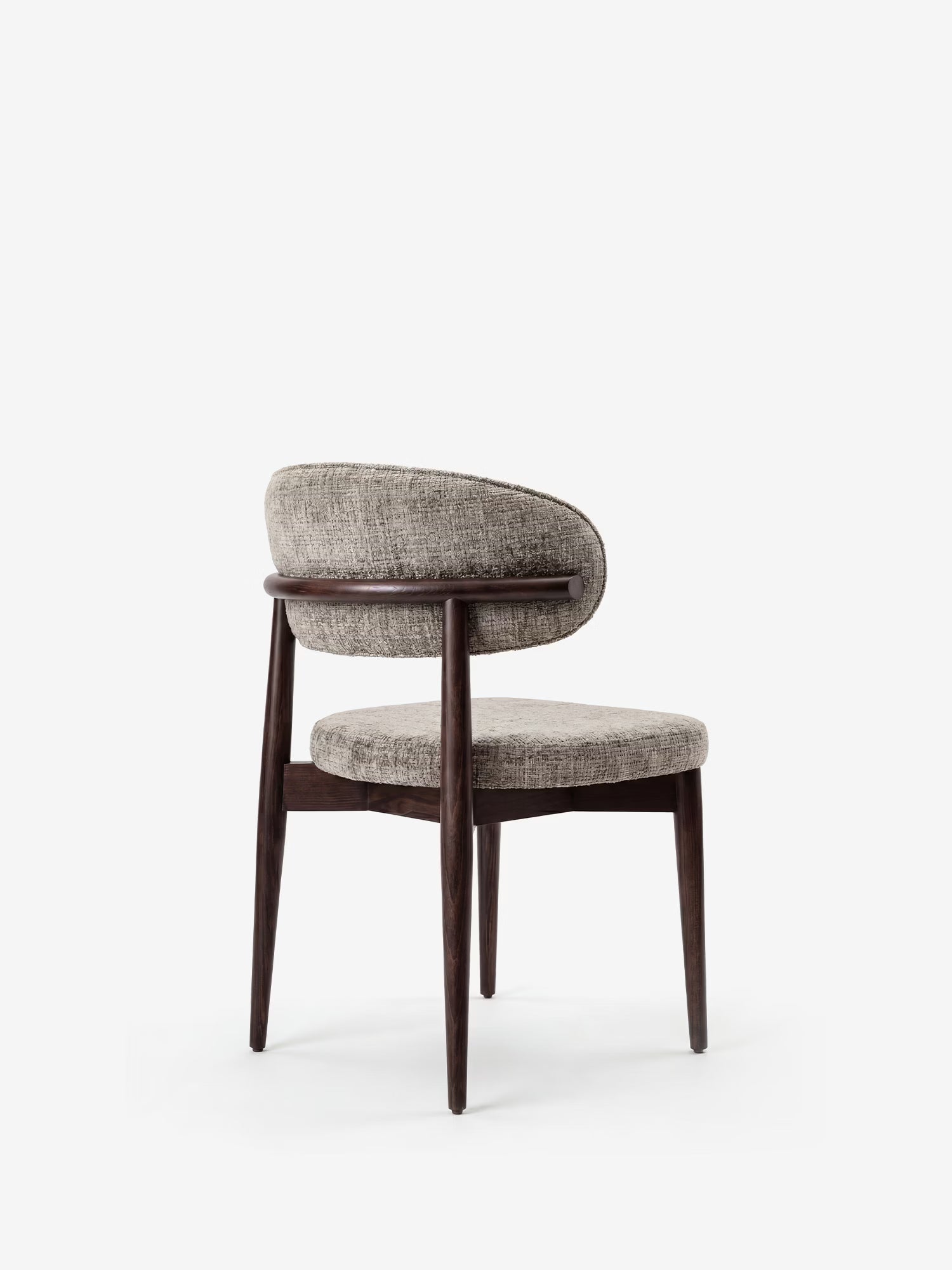 La sedia di design imbottita Dafne di Divani.Store presenta uno schienale curvo, una seduta rotonda in tessuto ciniglia certificato OEKO-TEX® e gambe in legno massello di wengé. Fotografata su uno sfondo bianco a tinta unita.