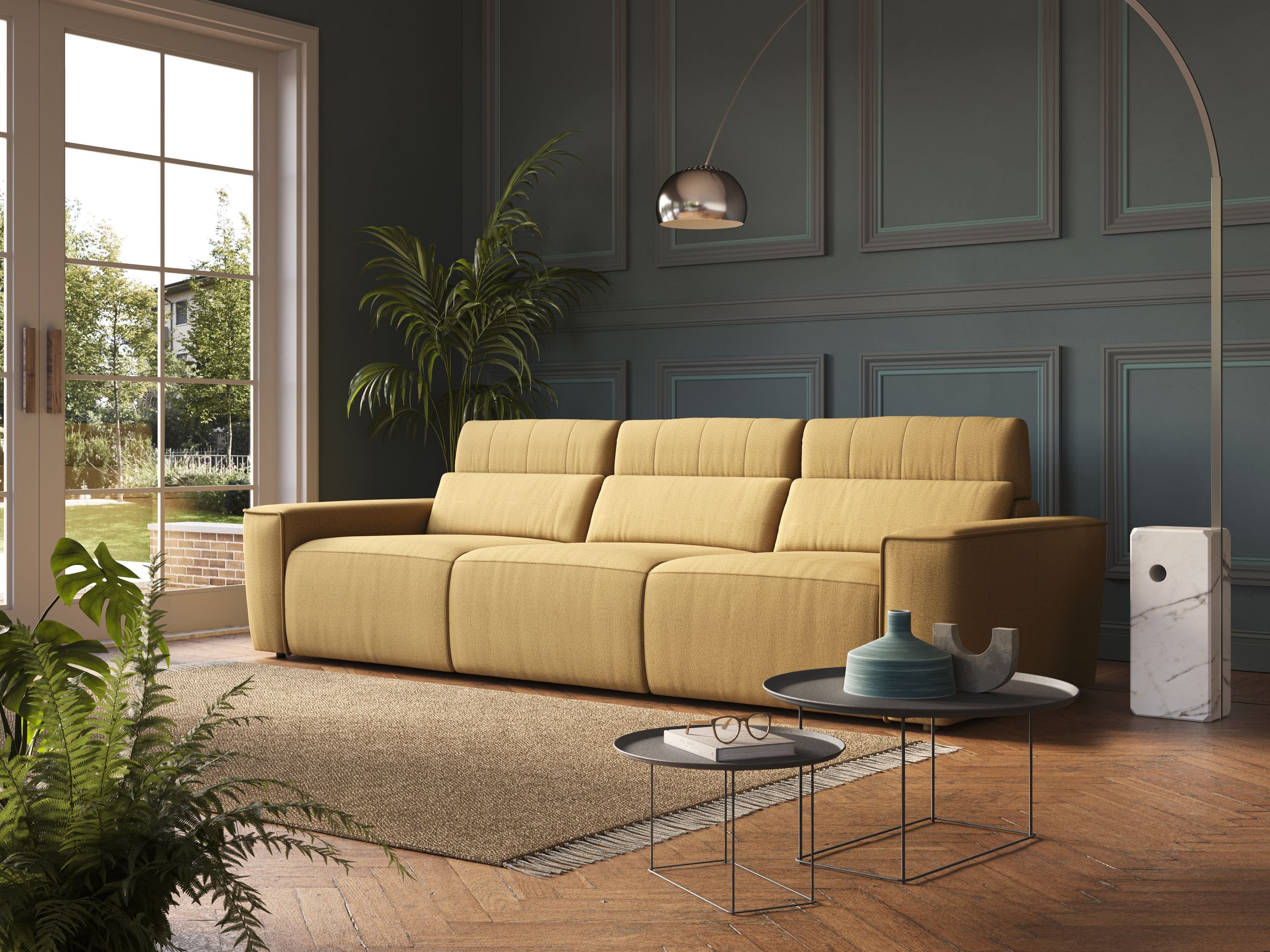 Un soggiorno moderno con un Clark Divano modulare 3 sedute con opzione relax elettrico in tessuto smacchiabile impermeabile T17 giallo di Divani.Store, pareti a pannelli scuri, pianta alta, lampada cromata ad arco, tavolini a nido, tappeto beige e ampie finestre sul verde.