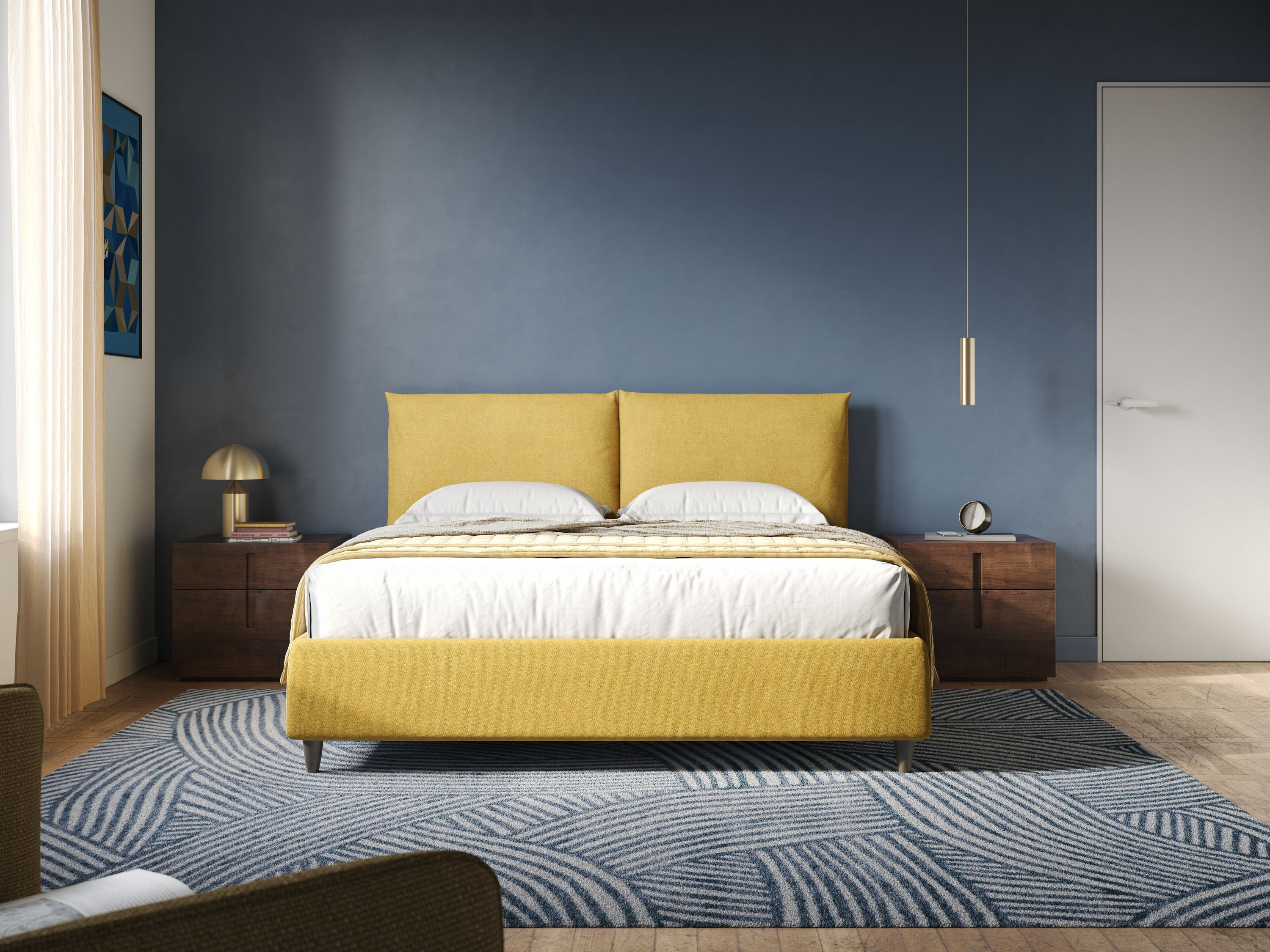 Una camera da letto moderna è caratterizzata dal letto imbottito Mariana contenitore con cuscini in tessuto impermeabile T02 giallo di Letti.store, dalla biancheria da letto bianca, da due cuscini, da una parete d'accento blu, da comodini in legno su ogni lato e da un tappeto a fantasia sul pavimento in legno.