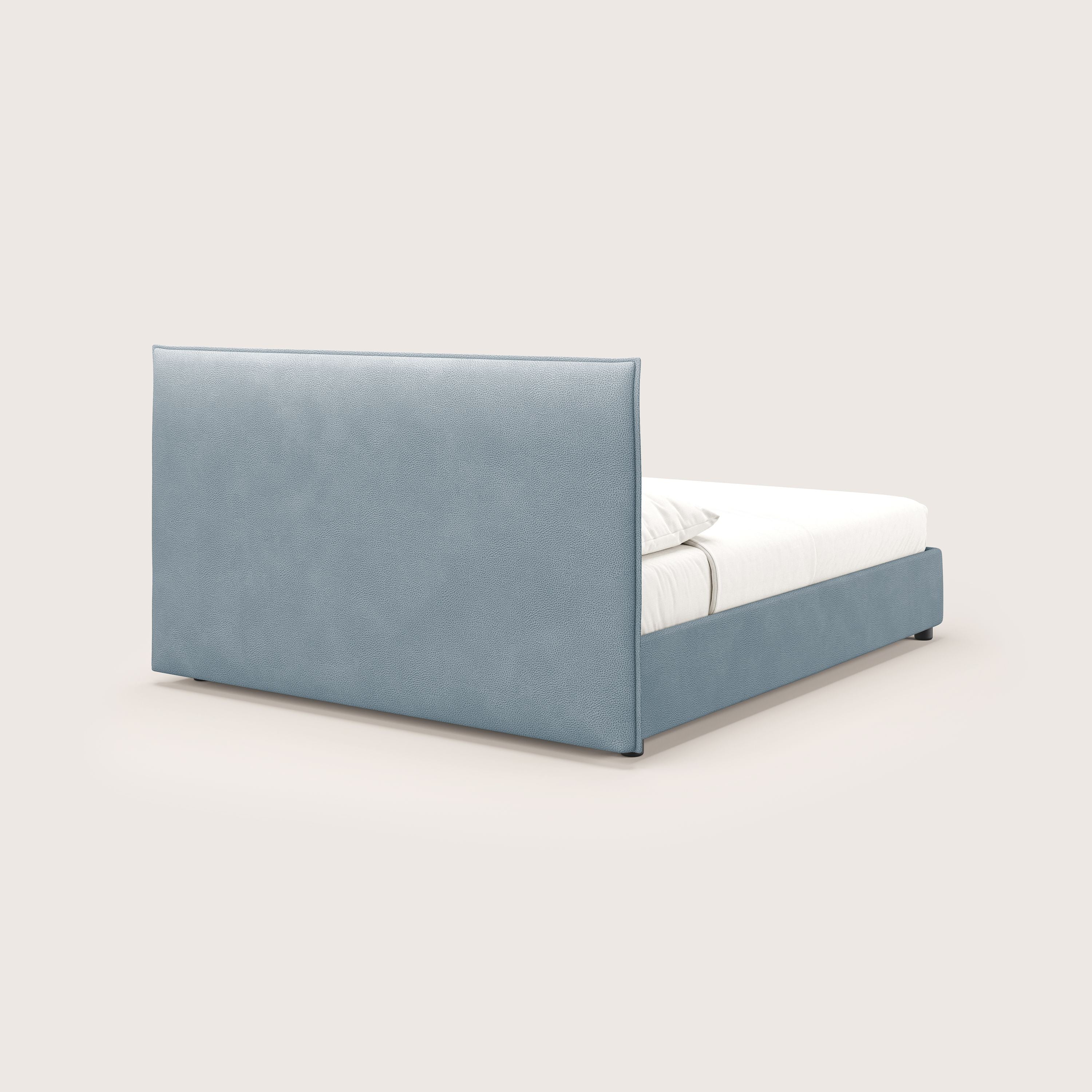 Il letto contenitore Nina di Letti.store è caratterizzato da un design minimale in ecopelle antimacchia carta da zucchero, con testata e struttura alte e imbottite, materasso e cuscini bianchi, su uno sfondo beige chiaro.