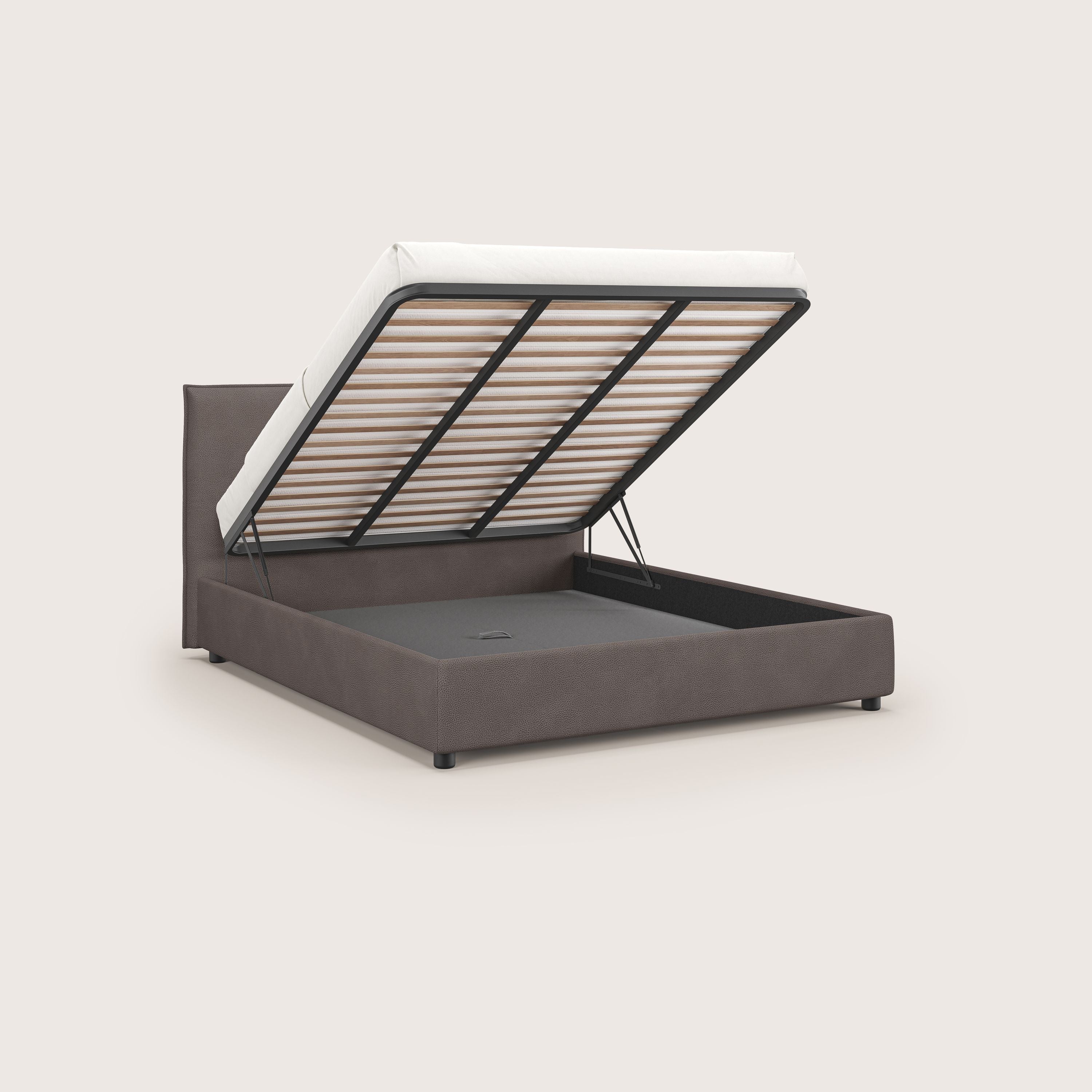 Il letto contenitore Nina di Letti.store è caratterizzato da un design minimale in tessuto antimacchia in microfibra marrone effetto pelle, da una semplice testiera rettangolare, da gambe corte nere e da un'alzata idraulica per un ampio spazio di contenimento.