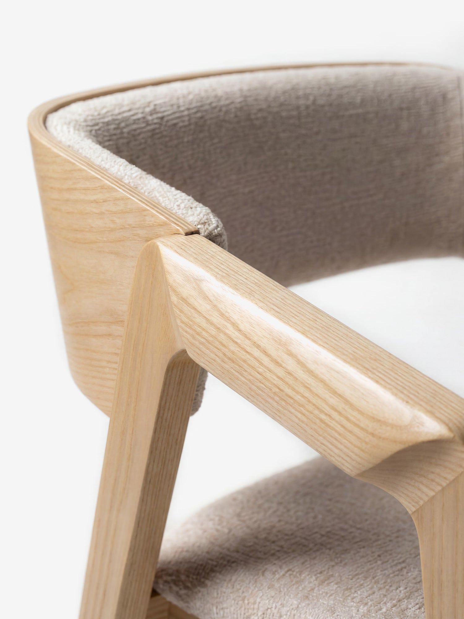 Primo piano della sedia Etra in legno massello naturale di Divani.Store, caratterizzata da braccioli, seduta imbottita in tessuto beige certificato OEKO-TEX® e schienale curvo. Le sue linee pulite e moderne risaltano su uno sfondo bianco a tinta unita.