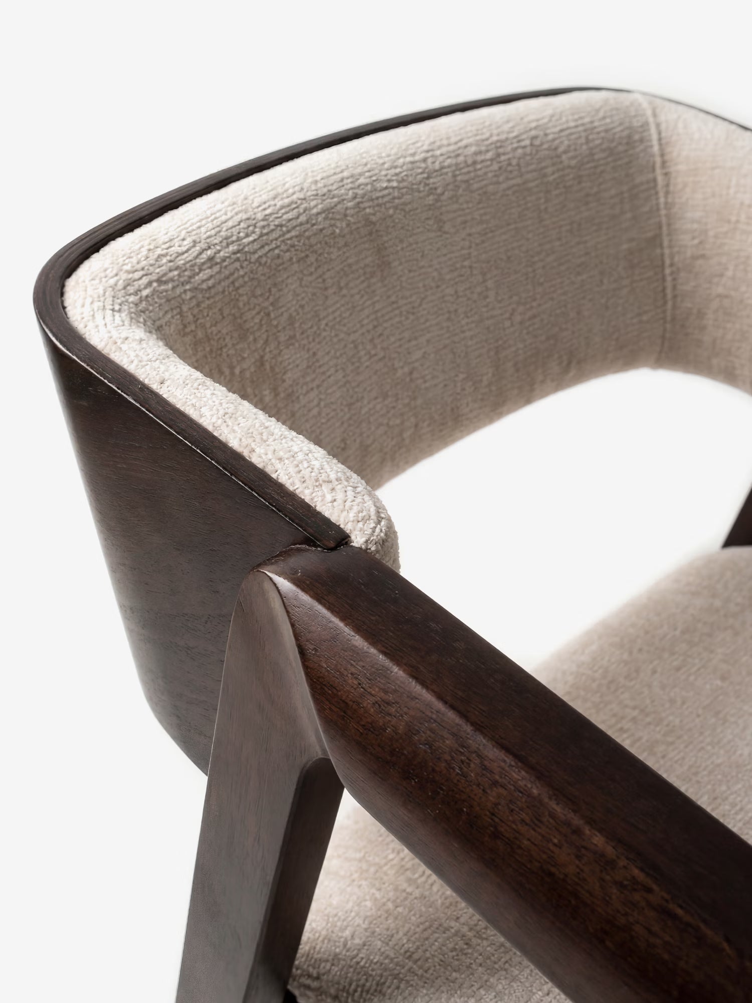 Un primo piano della Etra Sedia di Divani.Store ne mette in risalto la struttura in legno massello scuro, la seduta e lo schienale imbottiti in ciniglia beige con braccioli, il design moderno ed elegante e le linee morbide che risaltano sullo sfondo bianco.