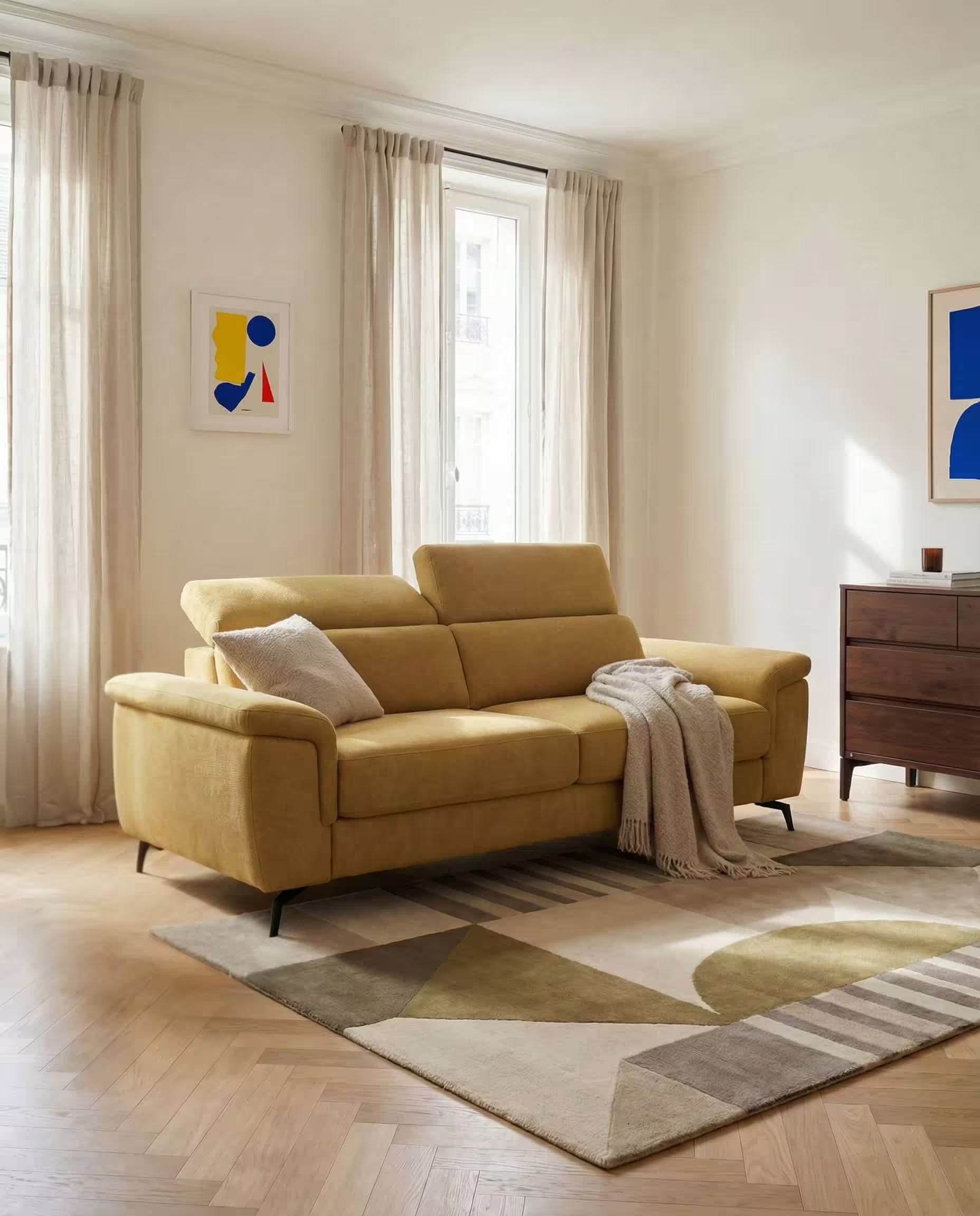 Un soggiorno moderno è caratterizzato dal divano Estro Divano 3 posti con pouf estraibile di Divani.Store in T14 giallo, da un cuscino grigio, da una coperta beige, da tende velate su finestre alte, da opere d'arte astratta su pareti bianche, da un tappeto geometrico e da un comò in legno scuro.