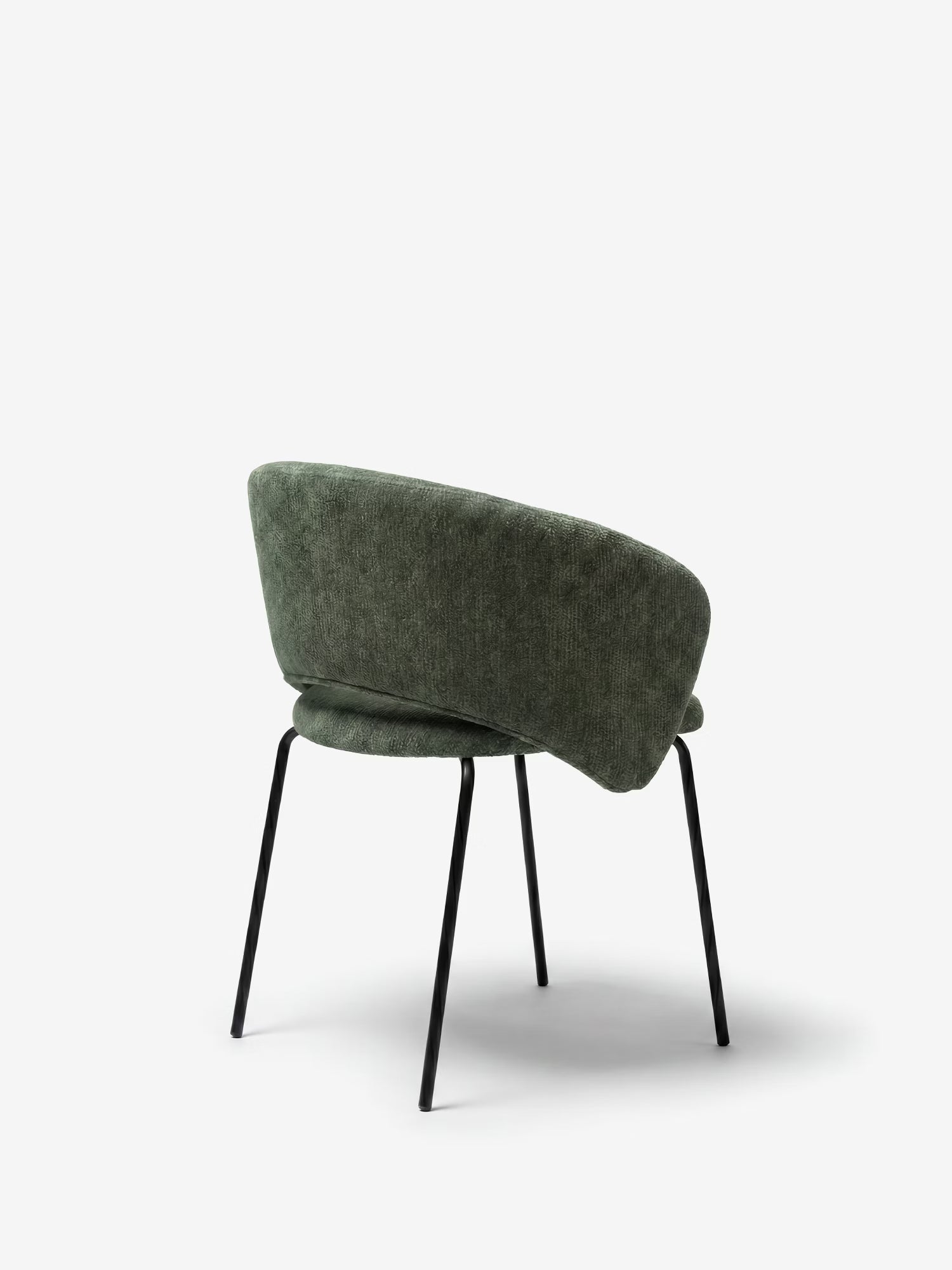 La sedia imbottita Fosca di Divani.Store presenta uno schienale arrotondato e avvolgente e una seduta in tessuto verde testurizzato certificato OEKO-TEX®, con quattro gambe sottili in metallo nero inclinate verso l’esterno, vista da dietro su uno sfondo bianco.