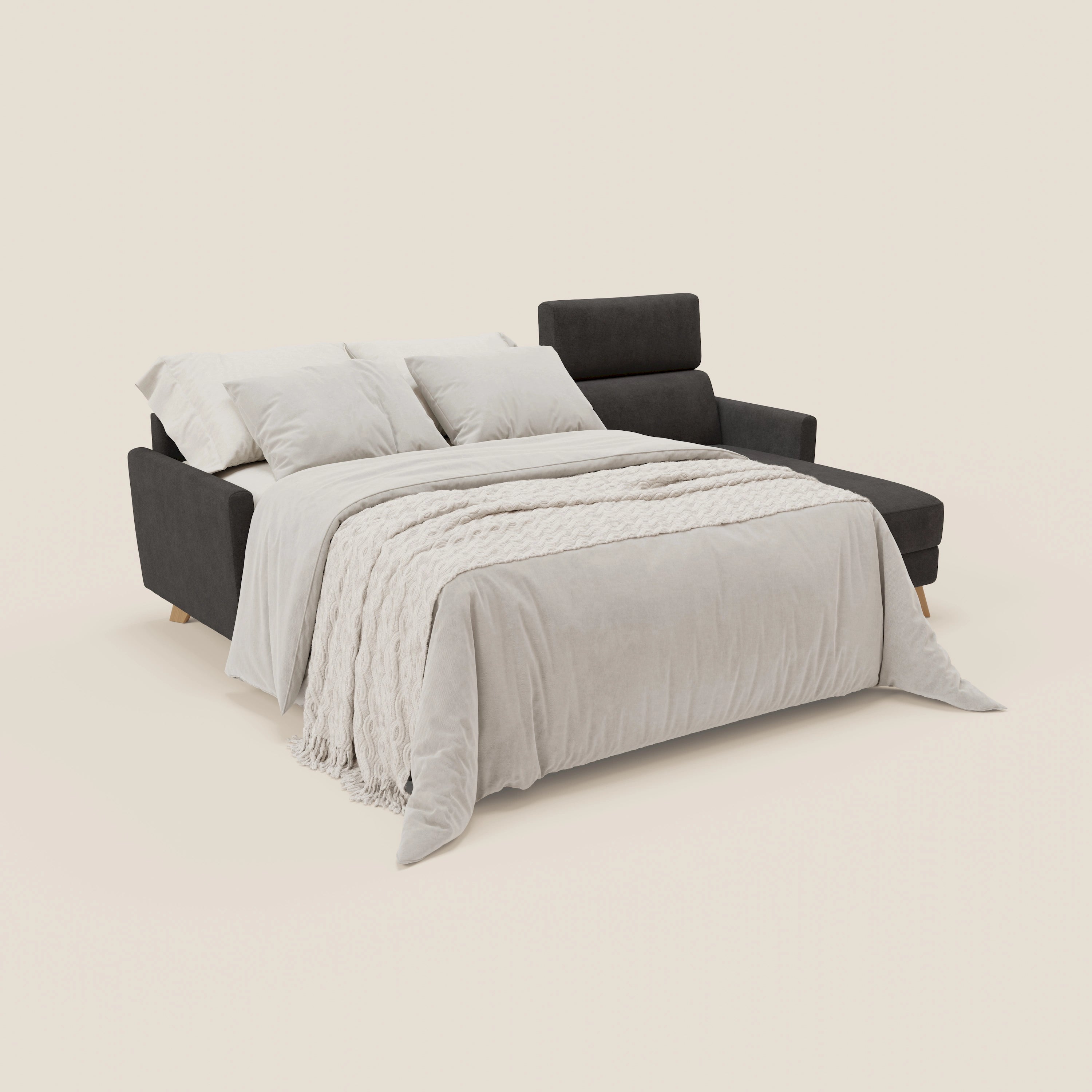 Il divano letto Francy angolare sfoderabile di Divani.Store, in tessuto smacchiabile T17 antracite, con penisola contenitore e poggiatesta reclinabili, è aperto a letto con plaid chiaro e cuscini, perfetto per uno stile nordico su sfondo neutro.