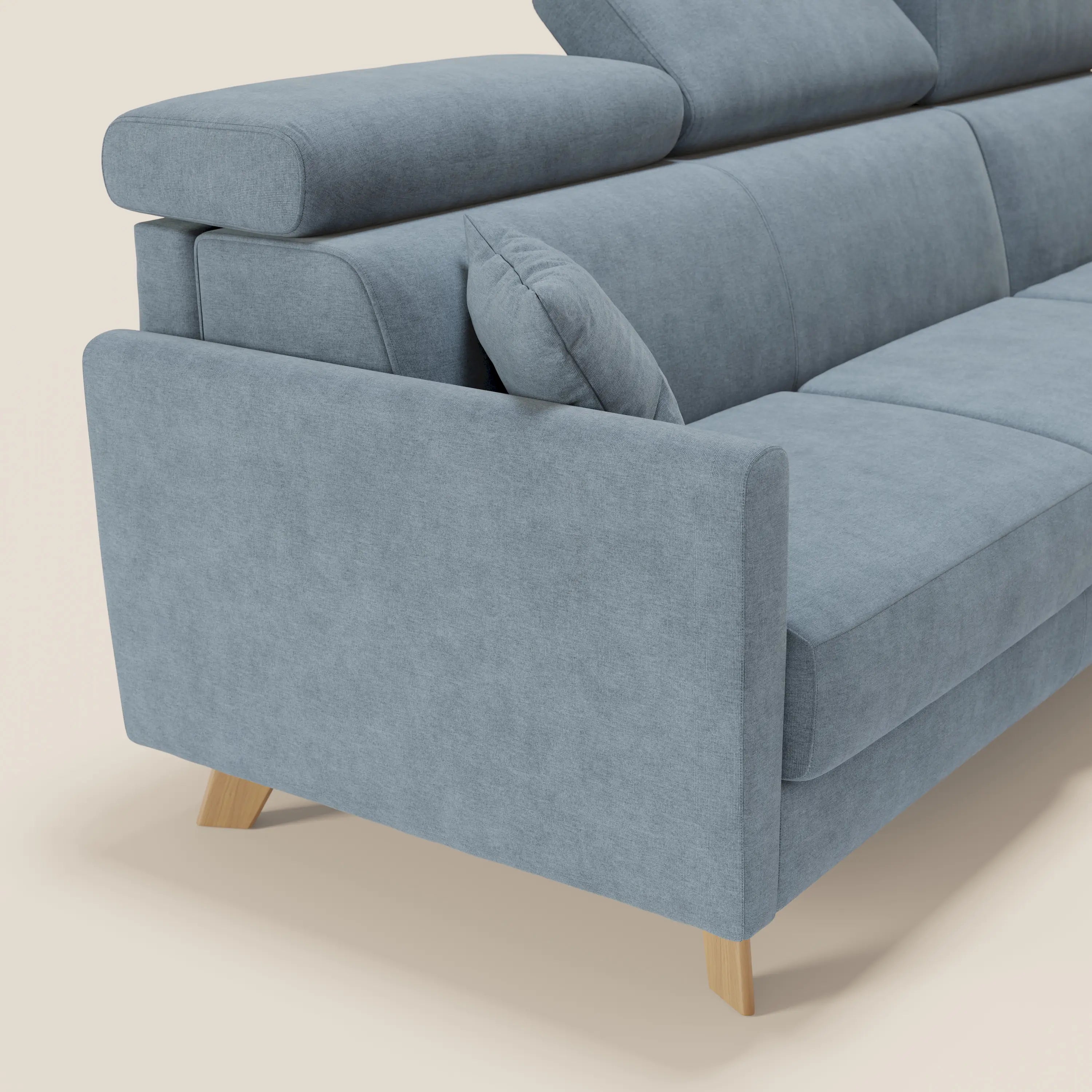 Il divano letto angolare sfoderabile Francy di Divani.Store, presentato in tessuto T17 carta da zucchero, è caratterizzato da una poltrona contenitore, da poggiatesta regolabili e da un cuscino coordinato su uno sfondo beige chiaro.