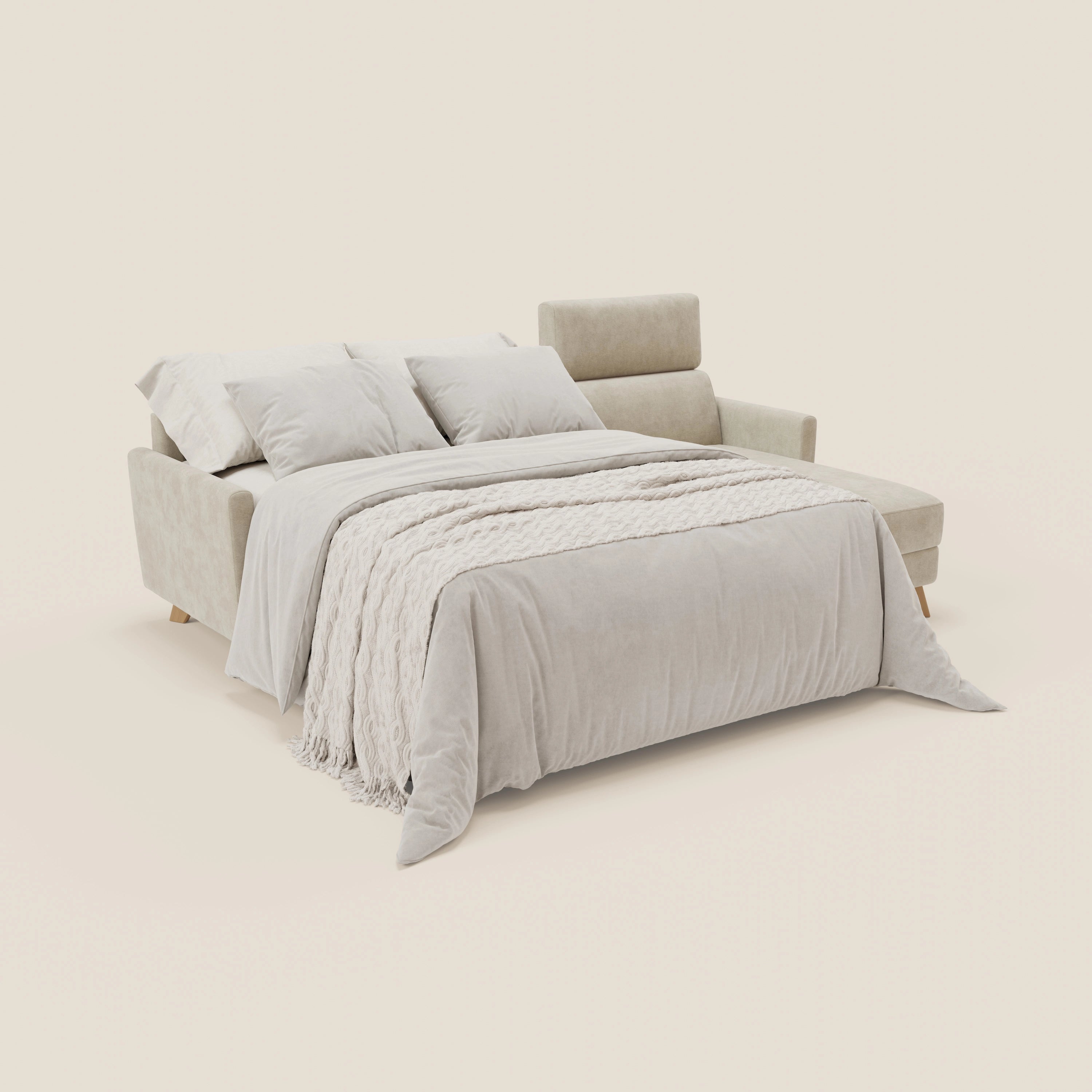 Il divano letto angolare sfoderabile Francy di Divani.Store in tessuto smacchiabile T17 panna, con chaise lounge, penisola contenitore e poggiatesta reclinabili, è presentato come un letto ben fatto con biancheria grigio chiaro e tre cuscini su sfondo beige.