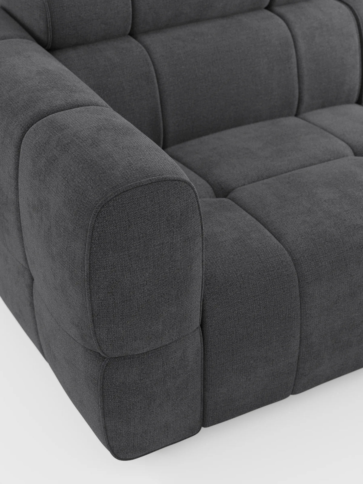 Una veduta dall'alto del divano modulare Giotto, grigio scuro, a 4 posti con poggiatesta reclinabili e funzione relax elettrica opzionale, rivestito in tessuto smacchiabile T23, caratterizzato da un motivo trapuntato a griglia in rilievo su uno sfondo chiaro a tinta unita.