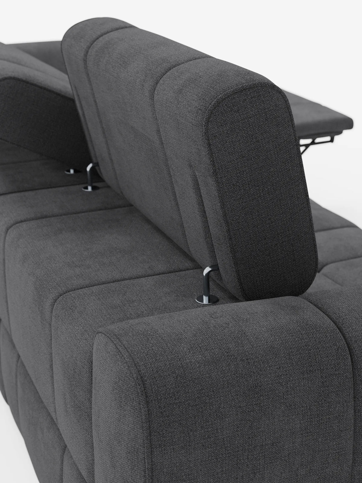 Un divano modulare Giotto grigio scuro a 4 posti con poggiatesta reclinabili e funzione relax elettrica opzionale, rivestito in tessuto smacchiabile T23, presenta poggiatesta regolabili su supporti in metallo argentato, che risaltano su uno sfondo a tinta unita.