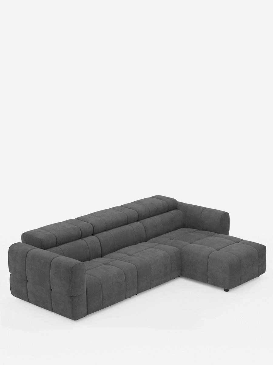Il divano angolare modulare Giotto a 5 posti da 296 cm con penisola e funzione relax elettrica opzionale, rivestito in tessuto smacchiabile T23, è un divano componibile grigio scuro dotato di chaise longue, tessuto trapuntato con motivo a griglia e braccioli a blocco dal profilo ribassato.