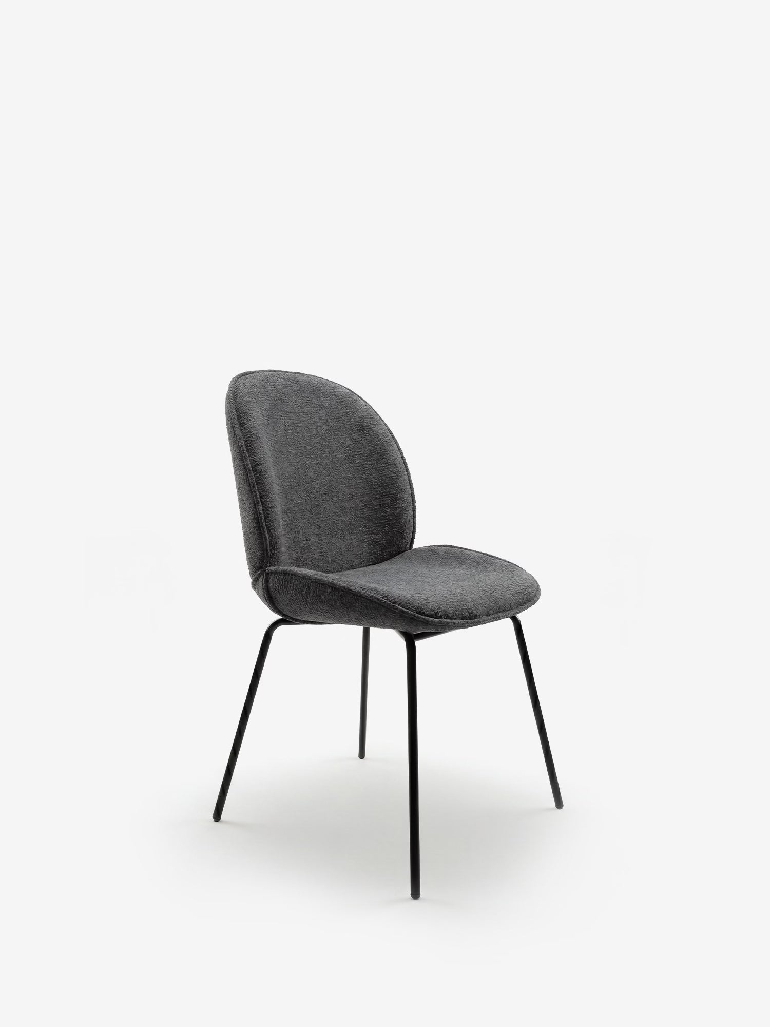 La sedia Iride, imbottita in morbido tessuto materico di Divani.Store, presenta una seduta grigio scuro dal tocco morbido, uno schienale curvo e quattro sottili gambe in metallo nero, in primo piano su uno sfondo bianco.