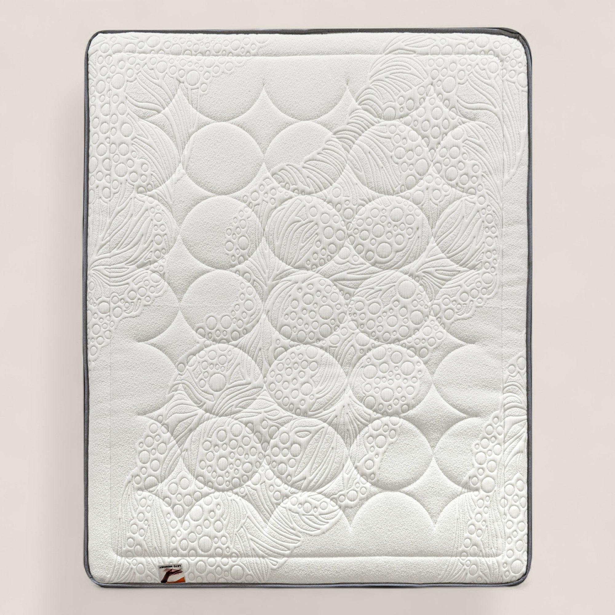 Il materasso KYROS di Divani.Store è rettangolare e bianco con angoli arrotondati, caratterizzato da una superficie trapuntata con cerchi e linee cucite. L'insacchettatura in micro-molle e gli strati di memory assicurano un comfort ottimale e un sostegno intelligente a 7 zone.