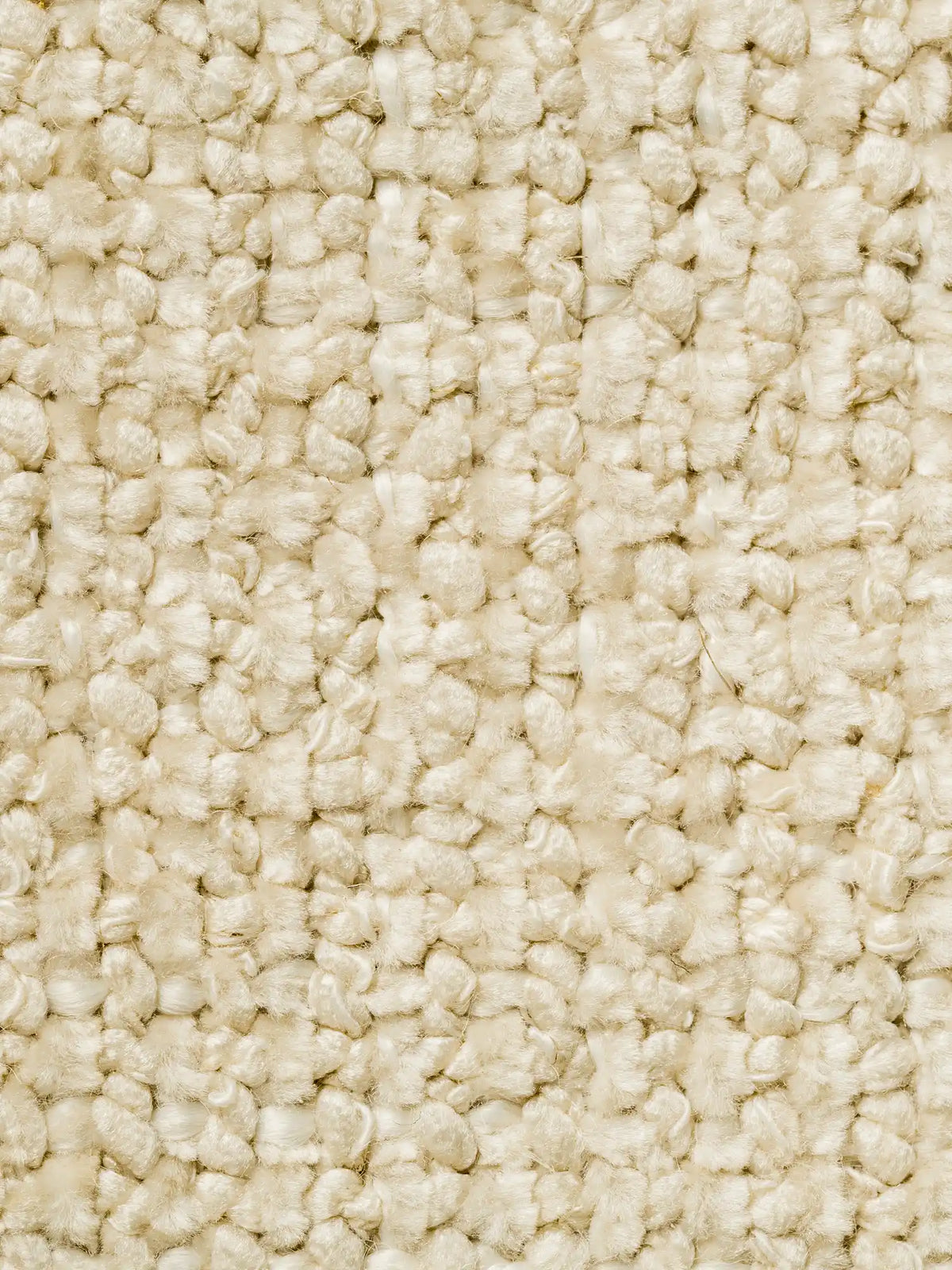 Un primo piano del tessuto S01 LIVIGNO, un tessuto soft-touch materico misto lino smacchiabile, di colore crema, caratterizzato da una trama grossolana e materica composta da fili spessi a ricciolo che creano una superficie morbida e irregolare, ideale per il rivestimento di un divano resistente.