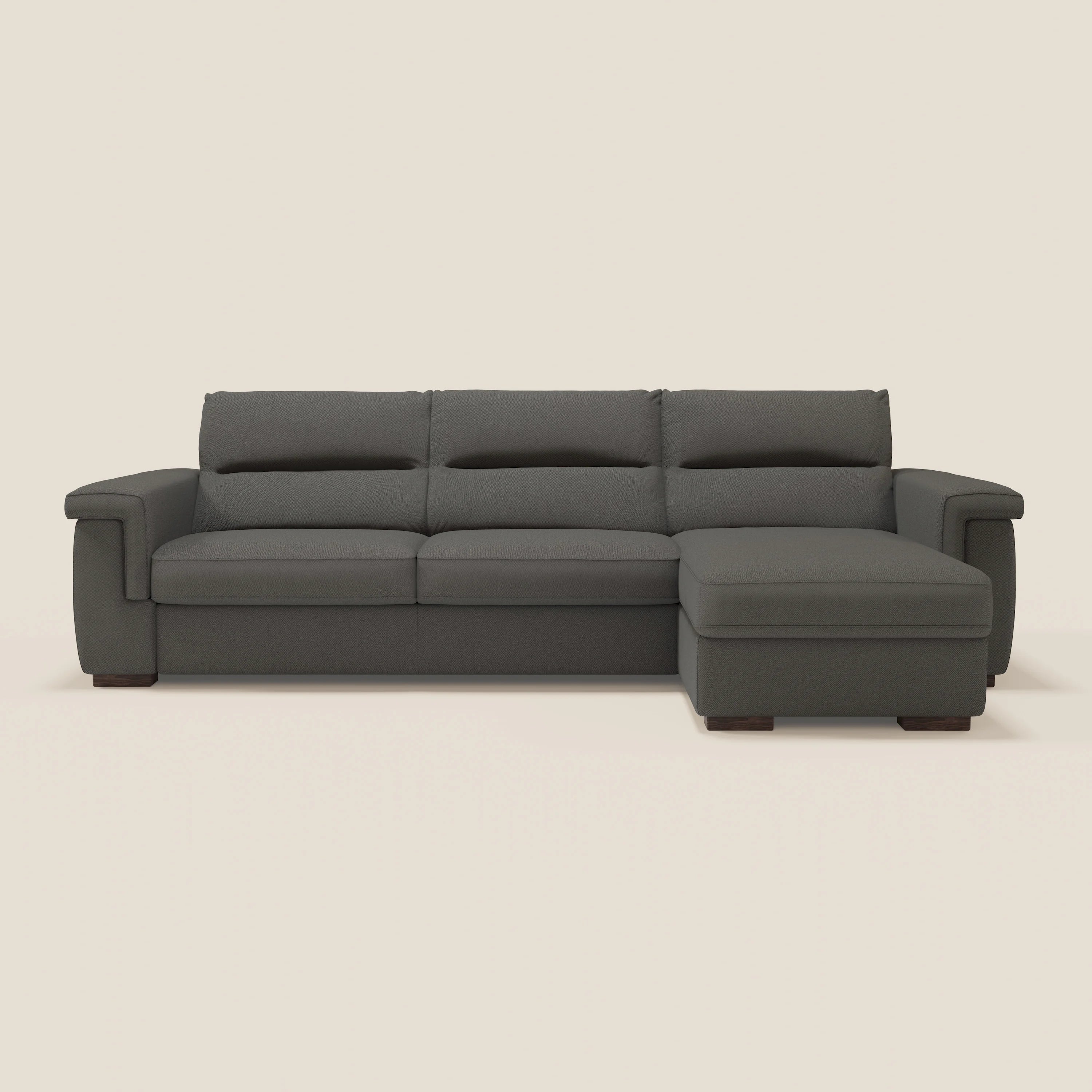 Il divano letto Magnolia angolare con penisola contenitore di Divani.Store, in tessuto smacchiabile T05 antracite, vanta ampi braccioli, schienali morbidi e gambe basse. Materasso H18 cm per Praticità Nascosta su uno sfondo beige chiaro.