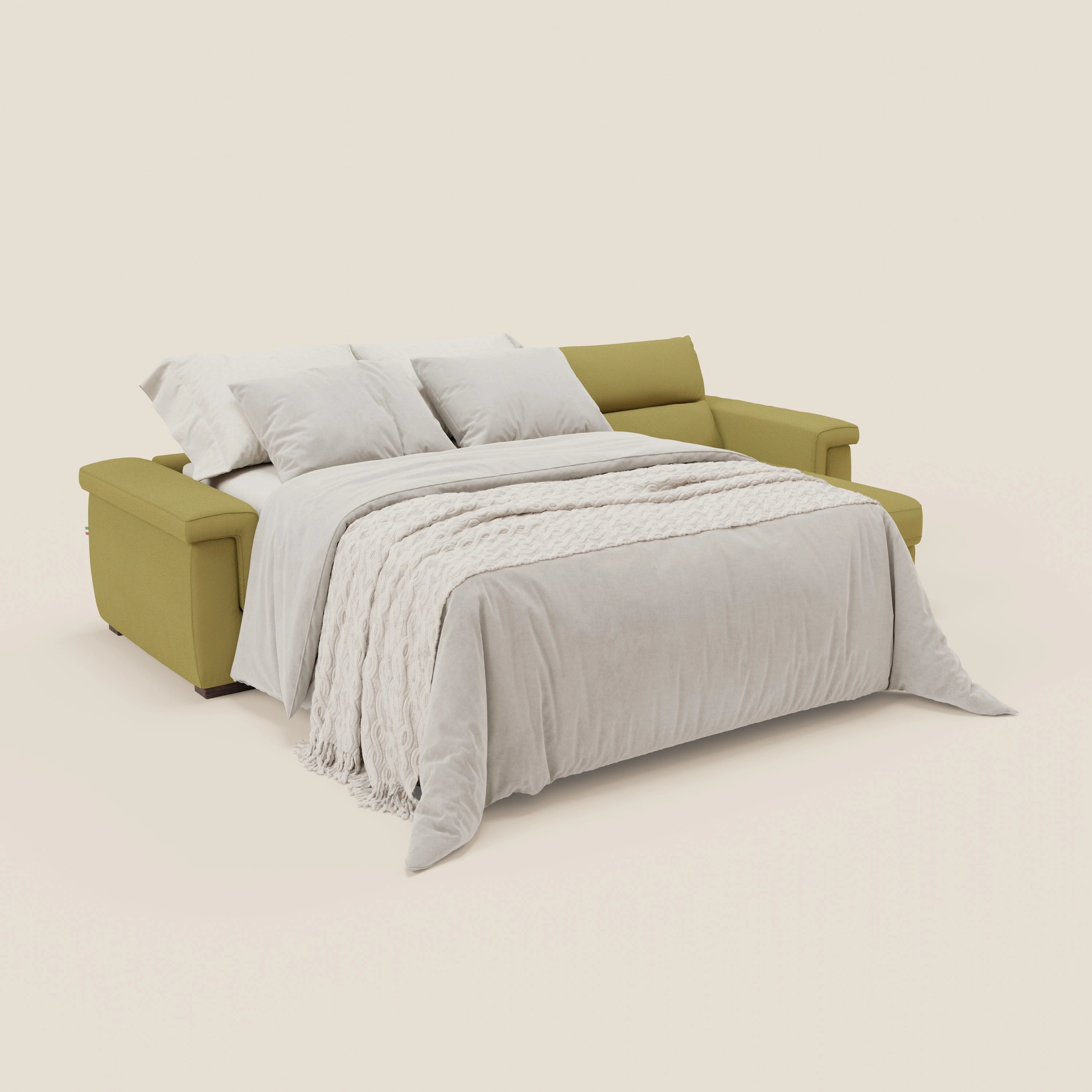 Il divano letto angolare Magnolia con Penisola Contenitore di Divani.Store, in tessuto smacchiabile T05 giallo e materasso H18 cm, è aperto a letto con coperta crema e tre cuscini coordinati, offrendo comfort profondo in uno stile minimalista su sfondo chiaro.