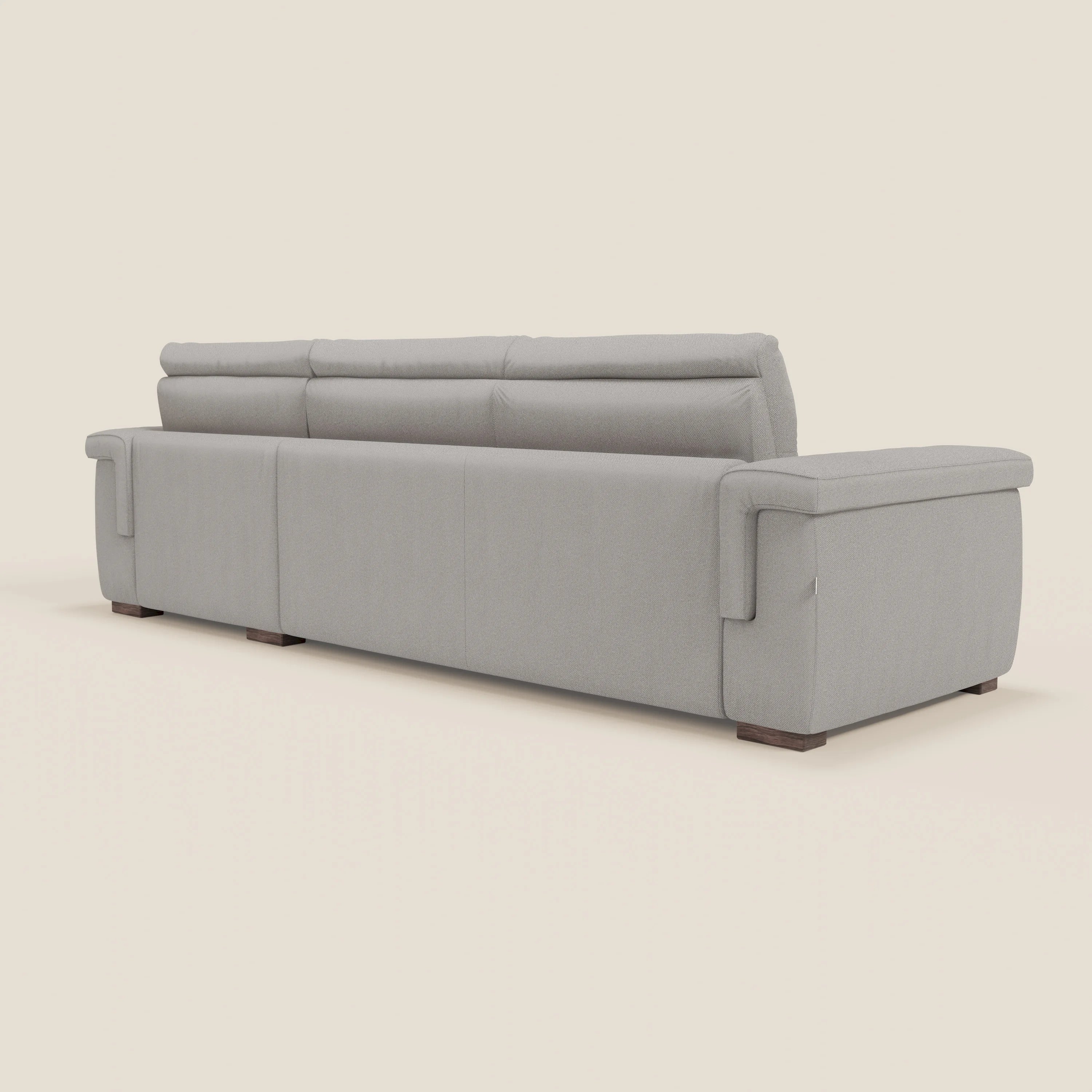 Il divano letto angolare Magnolia con penisola contenitore di Divani.Store è presentato di spalle e di lato, in tessuto smacchiabile T05 grigio chiaro con ampi braccioli, cuscini di schienale e piedini in legno su uno sfondo bianco sporco.