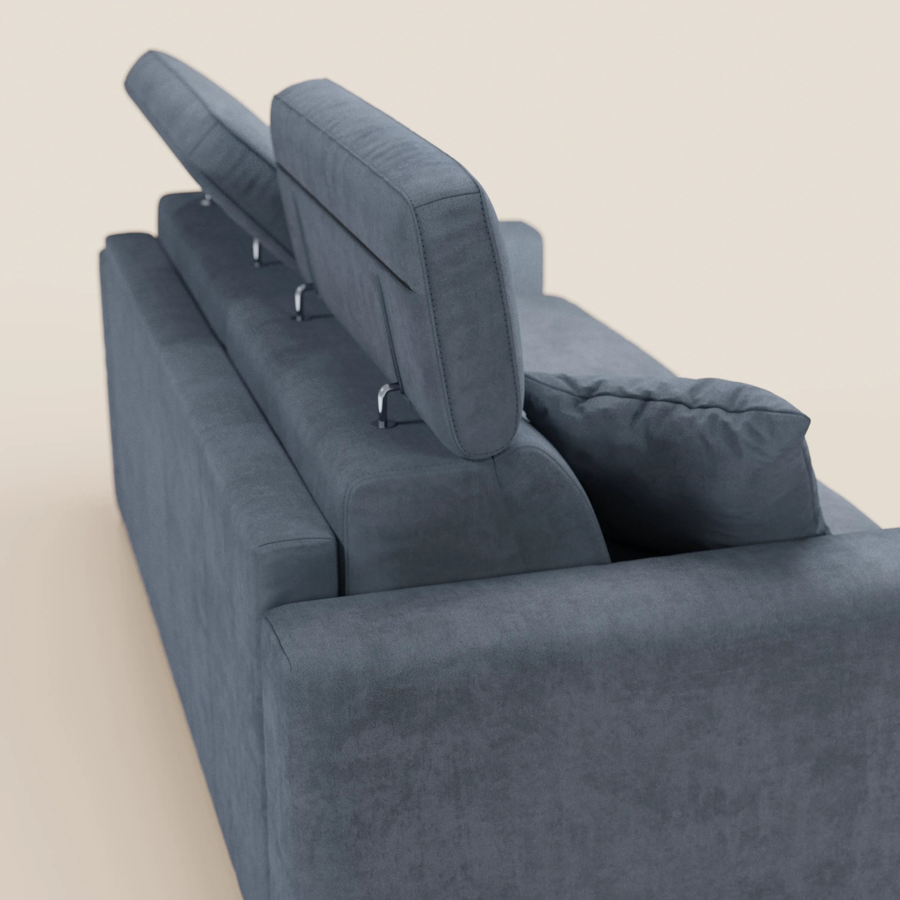 Un primo piano del divano letto Maximus a 3 posti con materasso ALTO da 20 cm di Divani.Store, realizzato in un tessuto moderno, grigio scuro, antimacchia e certificato Oeko-Tex, mette in evidenza i suoi poggiatesta reclinabili regolabili: due sollevati e uno abbassato. Il divano presenta linee pulite e dritte e un aspetto lussuoso, che risalta su uno sfondo semplice e chiaro che ne esalta l’elegante design.