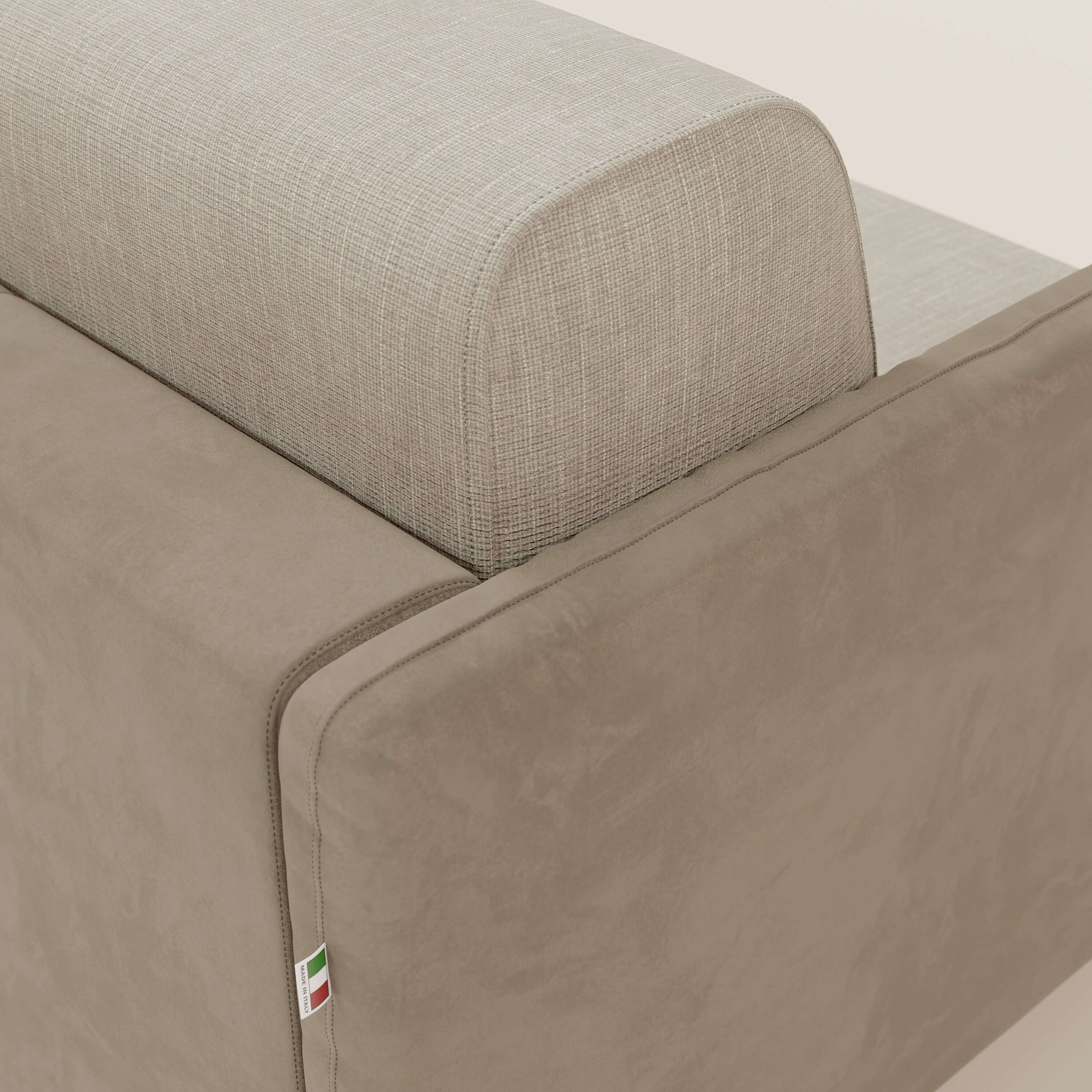 Primo piano del divano letto Narciso 160 cm di Divani.Store, caratterizzato da tessuto impermeabile T06 color tortora e microfibra panna. Una targhetta con la bandiera italiana sulla cucitura ne evidenzia la qualità artigianale.
