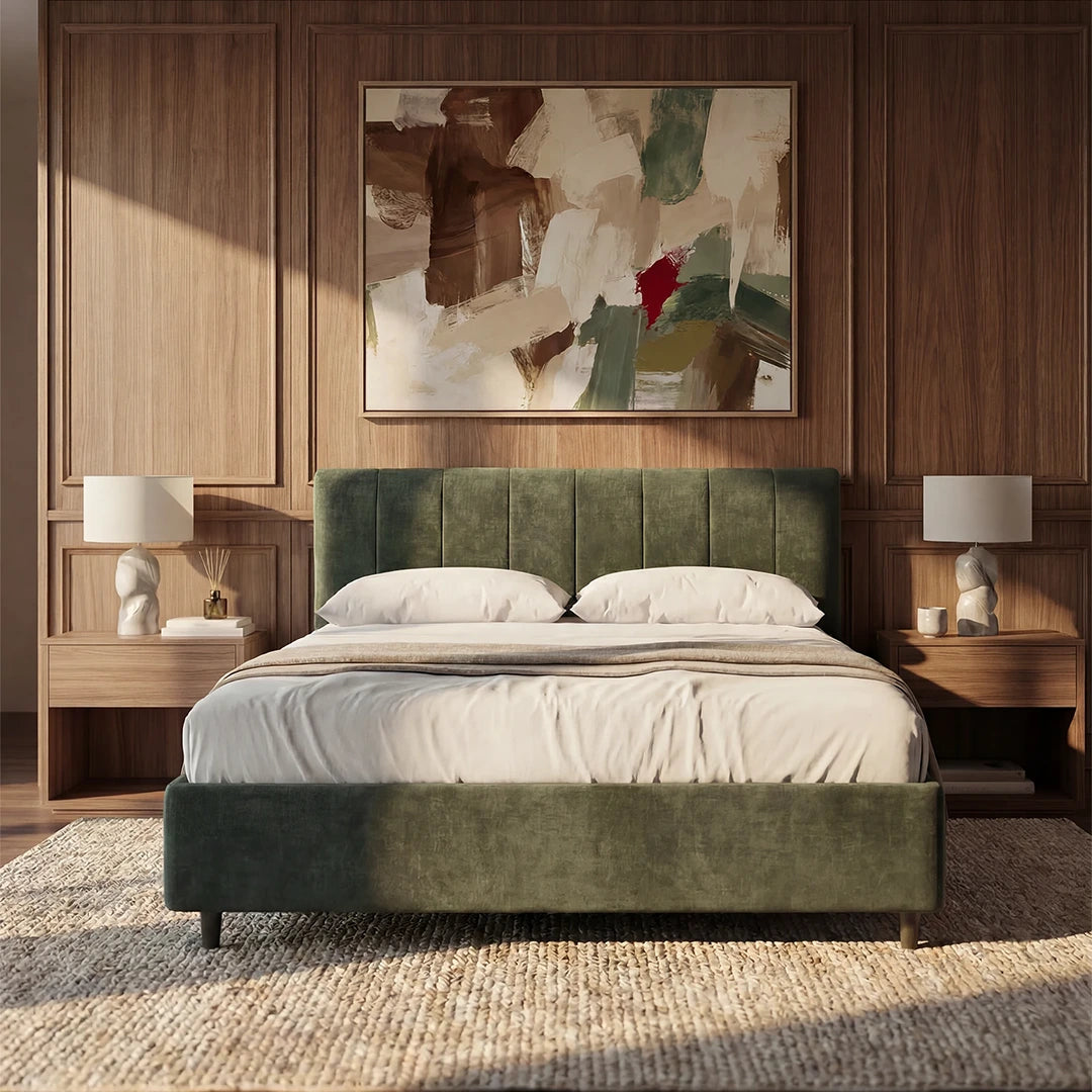 Una camera da letto moderna arredata con il letto imbottito ONYX con contenitore e testiera verticale in tessuto Oeko-Tex® di Letti.store, biancheria da letto bianca, comodini coordinati con lampade scultoree, rivestimenti in legno e un quadro astratto con accenti di rosso e verde.