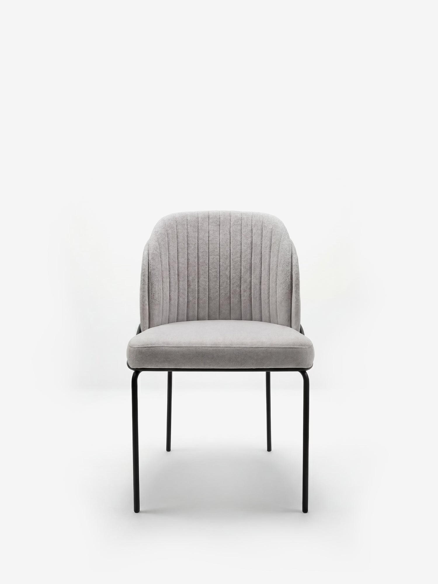 La sedia imbottita Plissè di Divani.Store presenta una seduta rivestita in tessuto grigio chiaro impermeabile e uno schienale con pieghe verticali, il tutto sostenuto da sottili gambe in metallo nero; il modello è raffigurato su uno sfondo bianco, che ne esalta lo stile contemporaneo e minimalista.