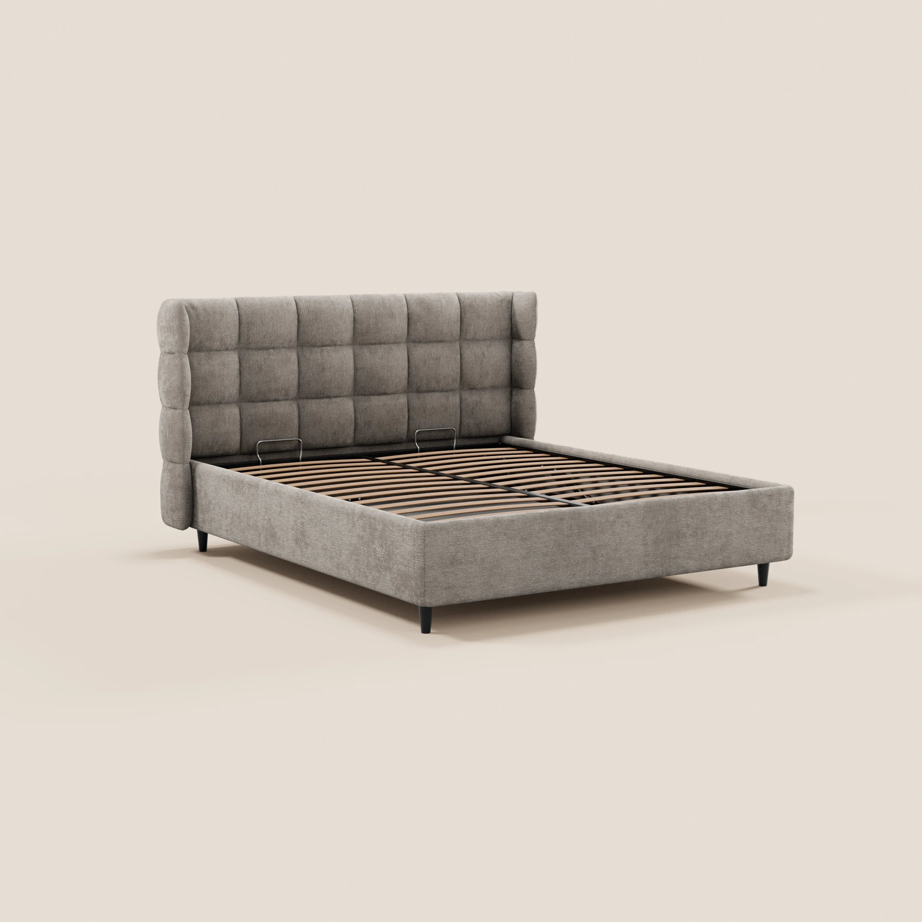 Il letto imbottito RAGNAR di Letti.store presenta una testiera alta e capitonné in tessuto certificato Oeko-Tex® e una base contenitore. Sorretto da gambe nere, il suo design pulito e minimalista risalta su uno sfondo beige a tinta unita.