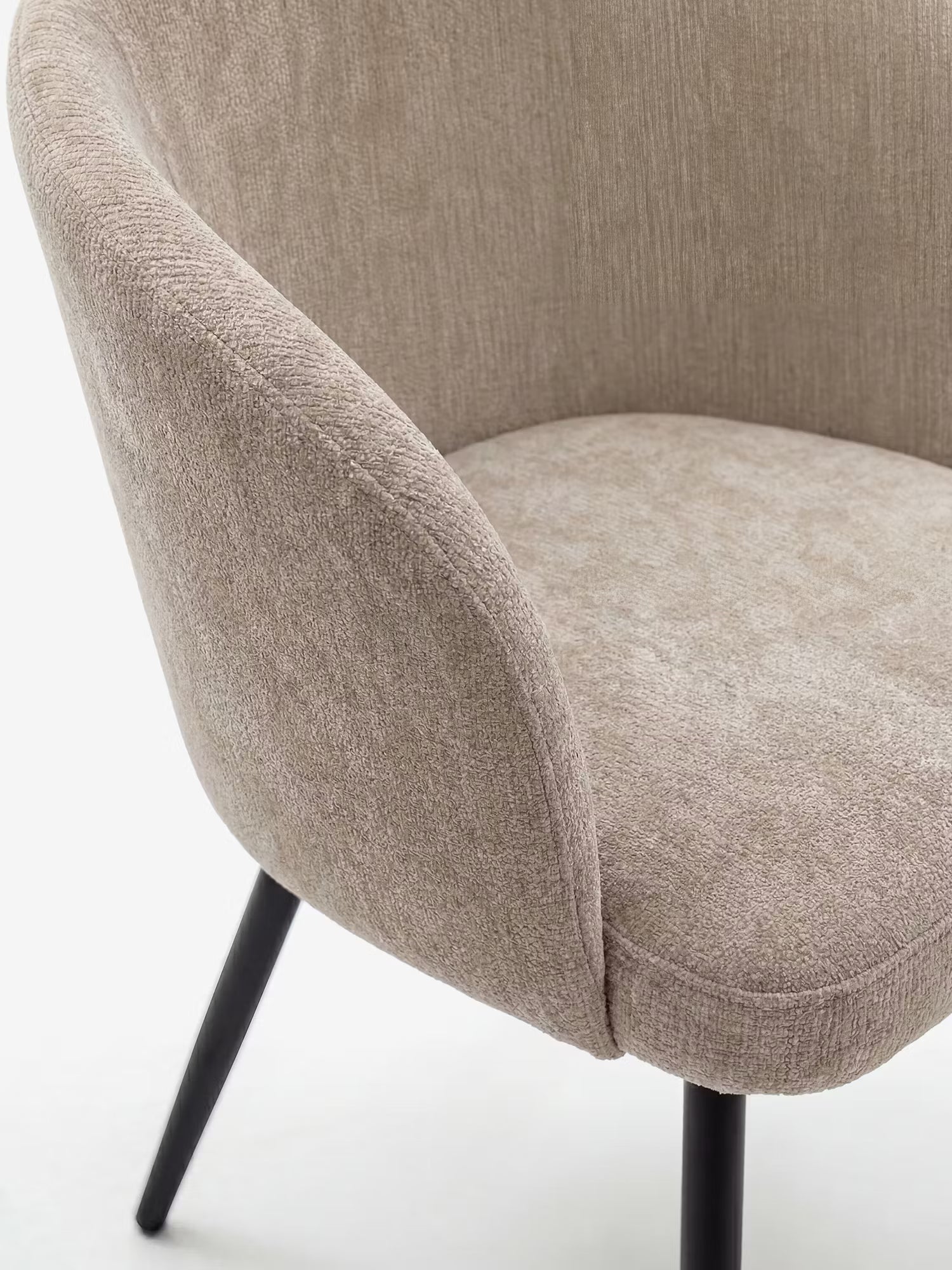 Un primo piano della Rovo Sedia con braccioli di Divani.Store, caratterizzata da un rivestimento in ciniglia beige chiaro, schienale e braccioli curvi e gambe in metallo nero, che ne esaltano l'elegante design contemporaneo su uno sfondo bianco a tinta unita.