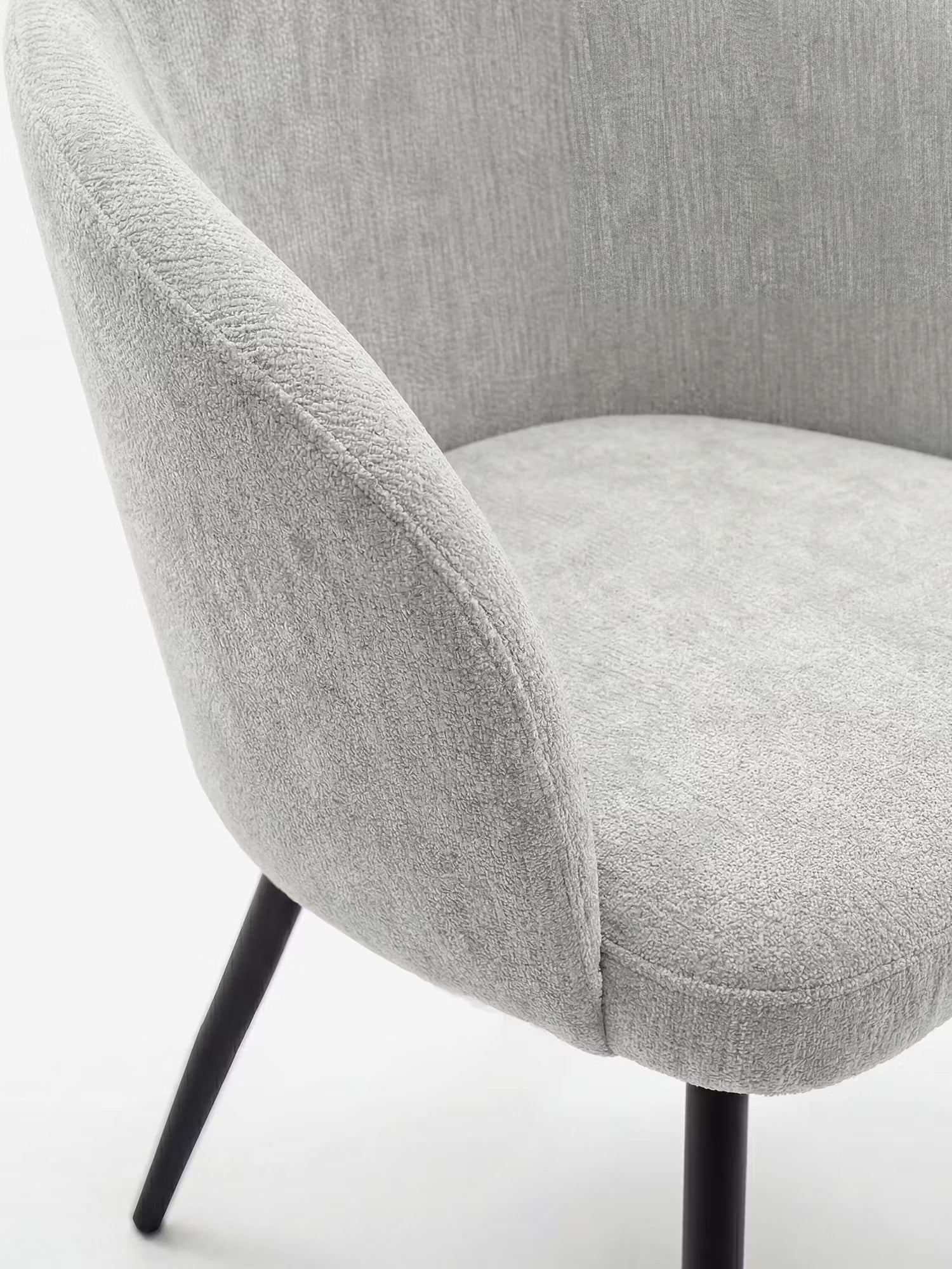 Un primo piano della Rovo Sedia con braccioli di Divani.Store, caratterizzata da un rivestimento in ciniglia grigio chiaro, uno schienale e braccioli curvi e gambe in metallo nero, che ne esaltano il design moderno su uno sfondo bianco a tinta unita.