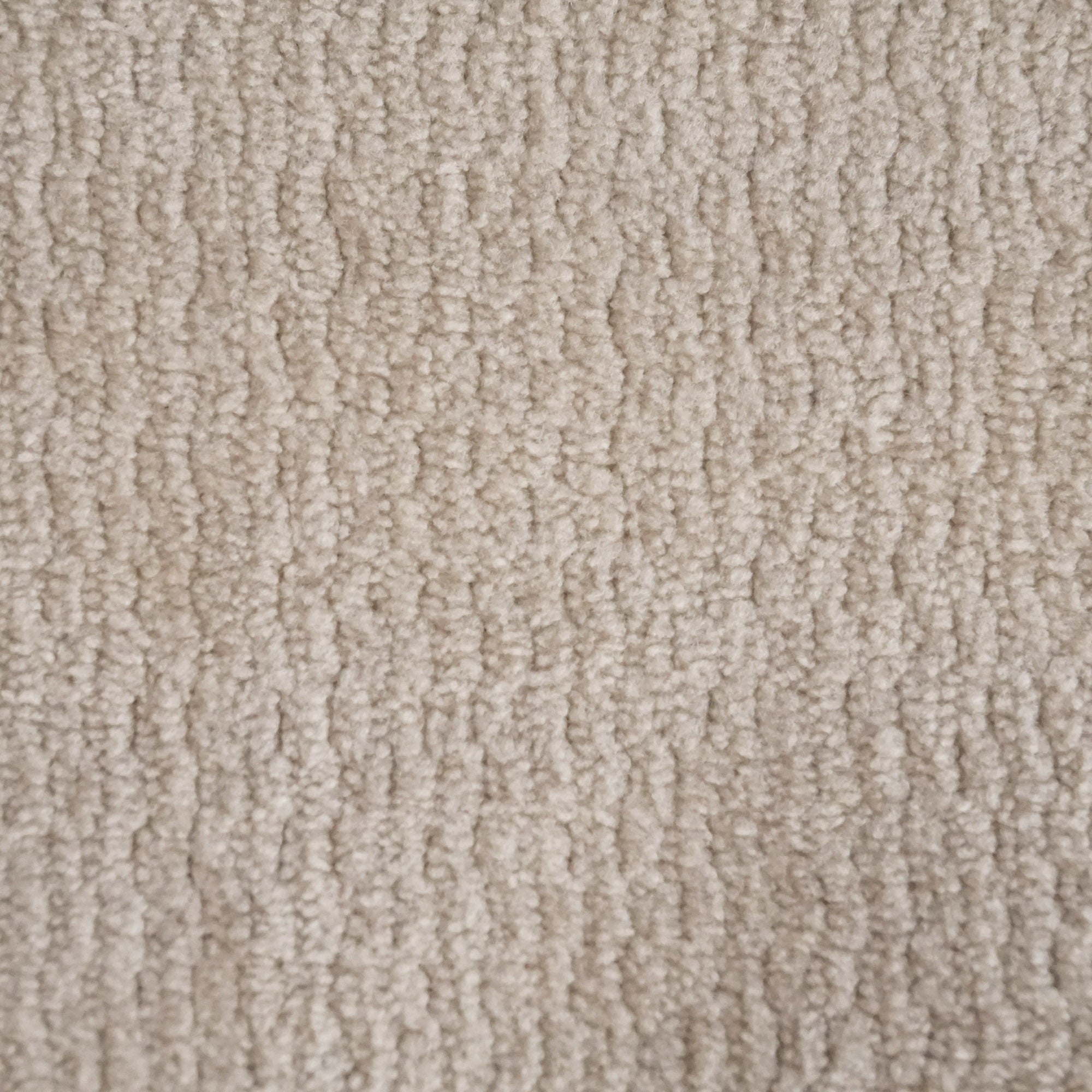 Primo piano di T32 Kendal di Divani.Store: un tappeto in morbida microfibra beige con un sottile motivo ondulato. Le fibre, fitte e morbide, offrono calore e intimità, mentre il trattamento impermeabile e smacchiabile garantisce una maggiore durata nel tempo.