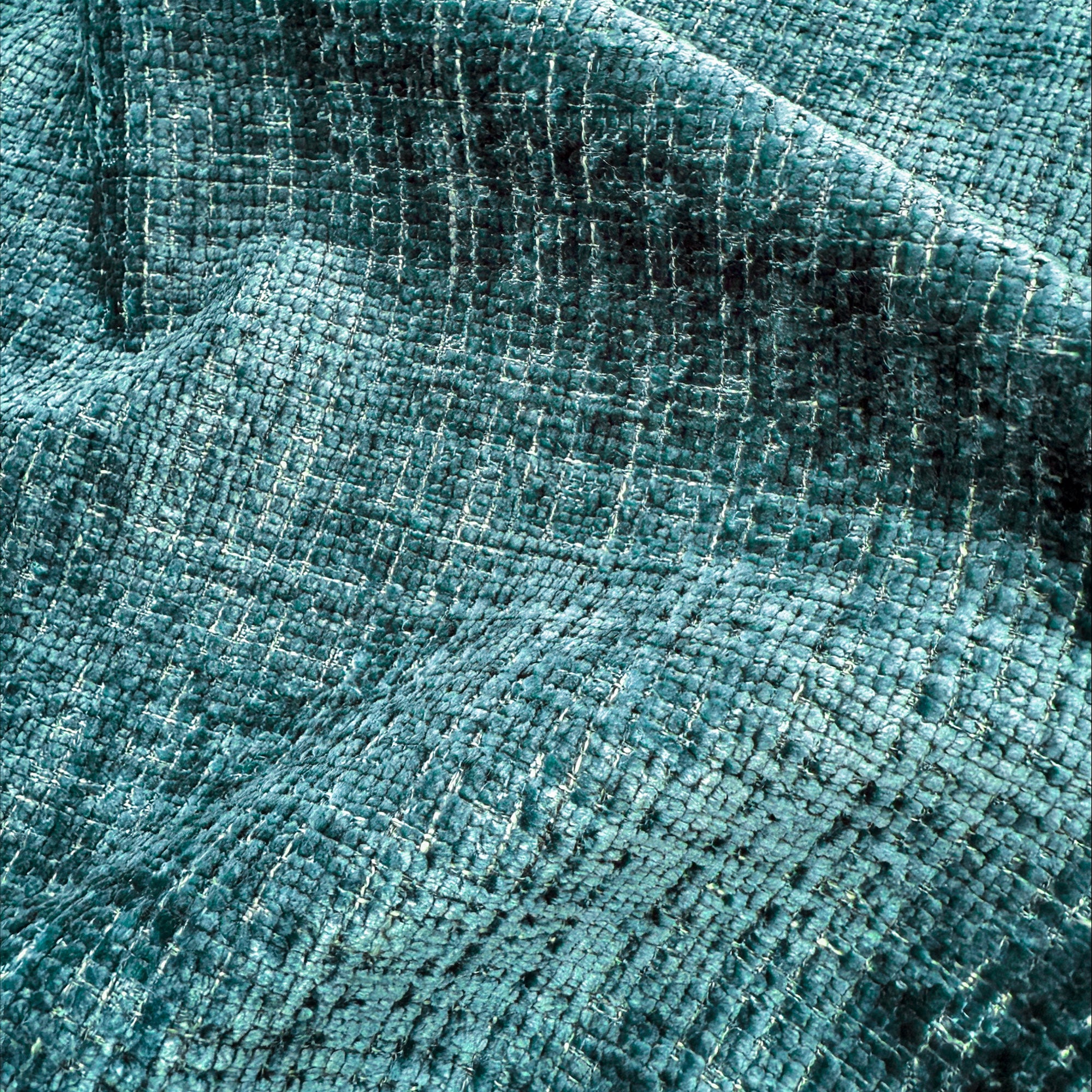 Primo piano di T28 River Eleganza di Divani.Store: un tessuto pregiato verde acqua con trama a rilievo, finitura smacchiabile e protettore di superficie per una morbidezza e una durata durature.