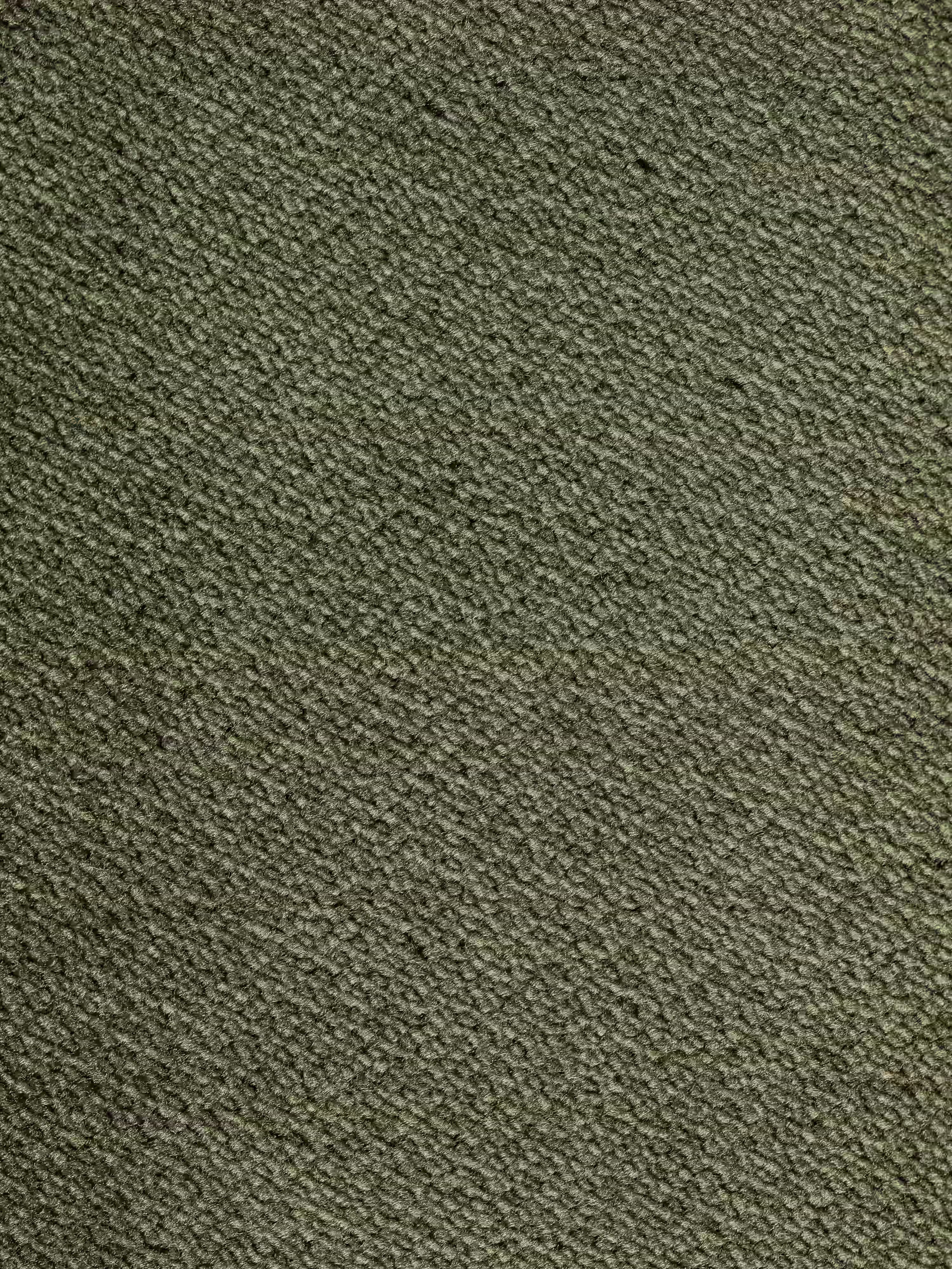 Un primo piano dell’elegante tessuto vellutino grigio del divano Michelangelo 4 Posti di Divani.Store, caratterizzato da una delicata trama diagonale tipica di questo divano moderno. Una sottile cucitura orizzontale attraversa il centro, distinguendo delicatamente la parte superiore da quella inferiore. Il tessuto smacchiabile conferisce un aspetto morbido e sobrio, perfetto per le tre sedute estensibili di questo spazioso divano con poggiatesta reclinabili.