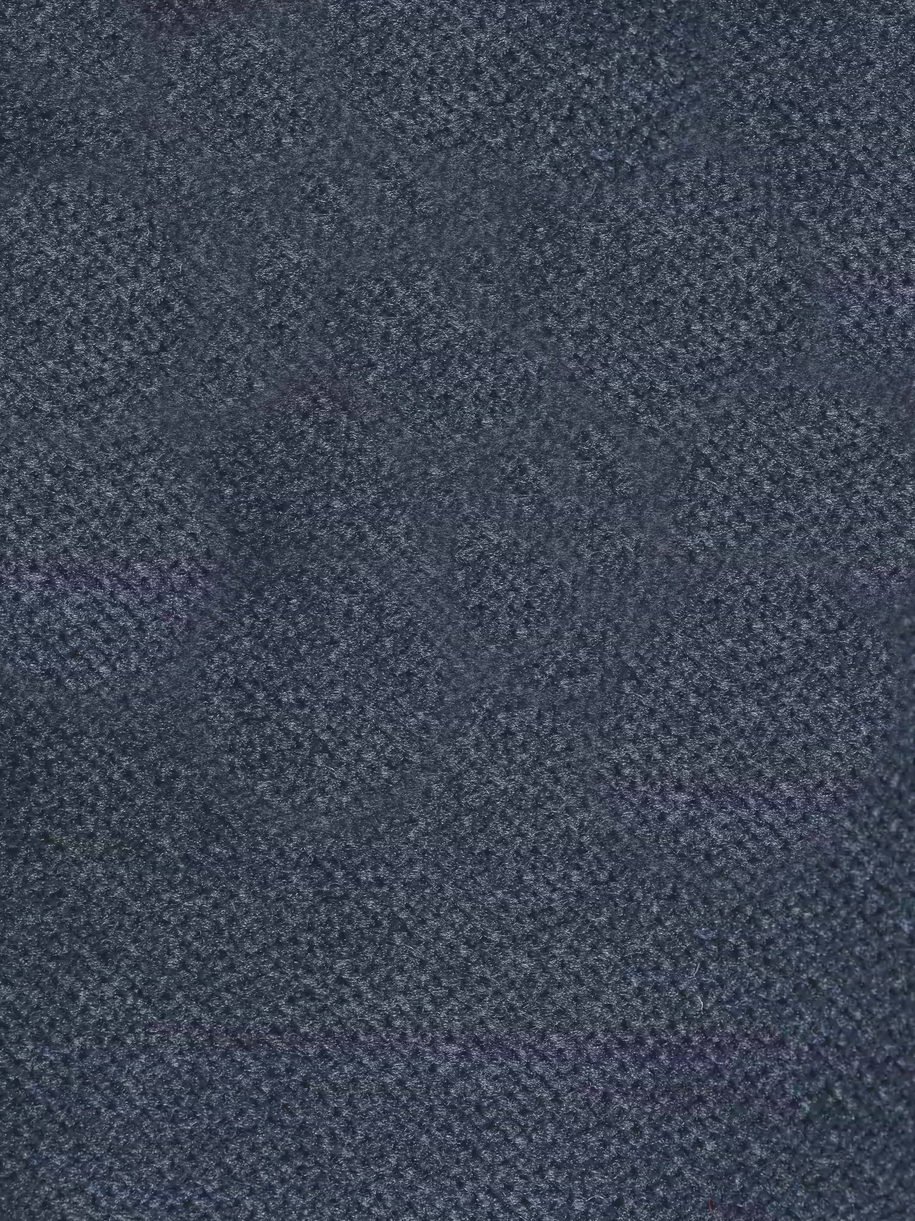 Un primo piano del raffinato tessuto T30, di colore grigio scuro, smacchiabile ed effetto vellutato, mette in risalto una morbida trama intrecciata con un delicato motivo screziato: perfetto per il rivestimento del divano angolare Michelangelo con penisola e sedute estensibili di Divani.Store. Le delicate variazioni tonali sulla superficie ne esaltano il fascino sofisticato, rendendolo ideale per eleganti divani componibili con poggiatesta reclinabili.