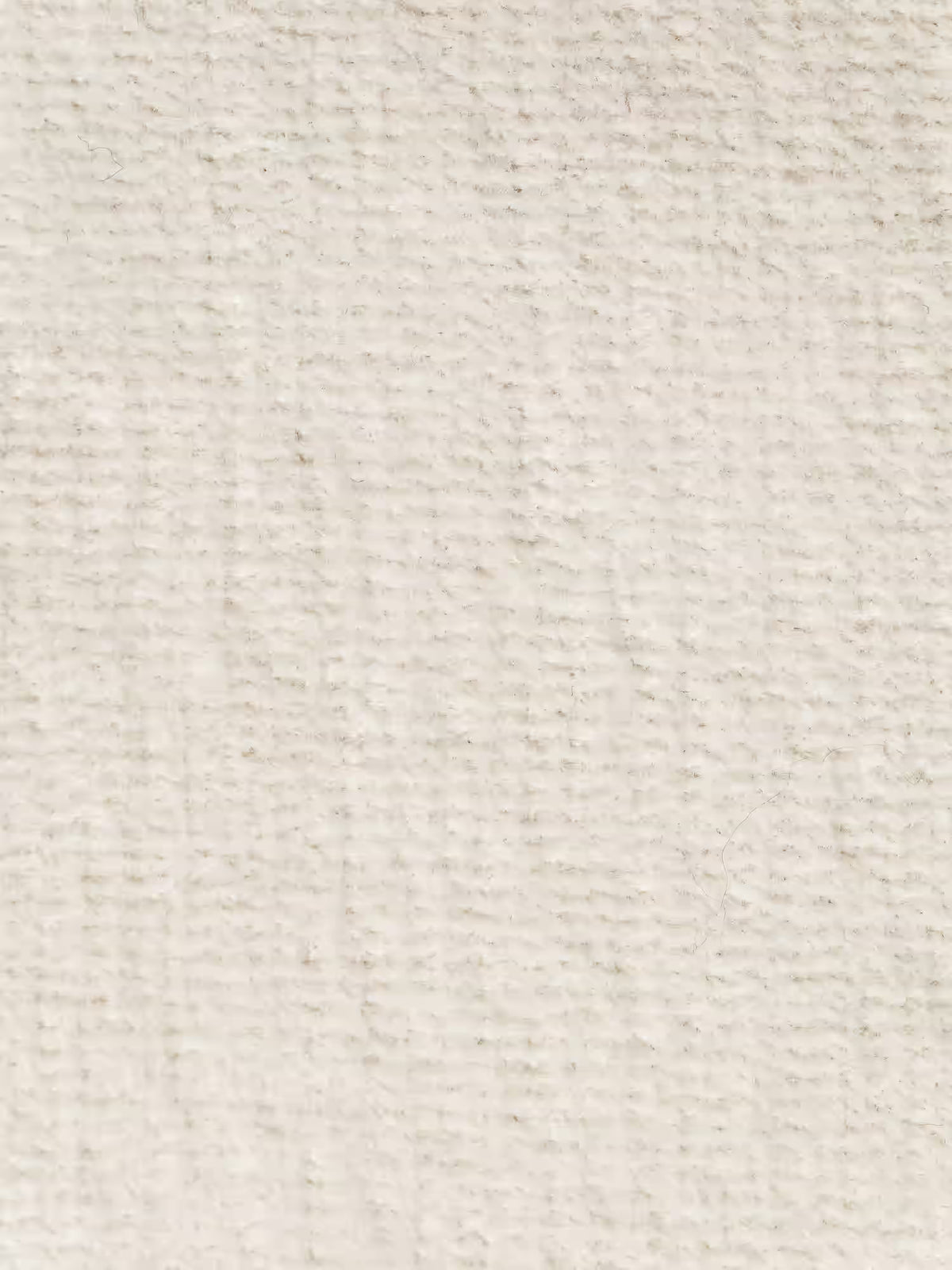 Primo piano del divano moderno angolare con penisola “Basalto” di Divani.Store, rivestito in tessuto smacchiabile T31 beige a trama rigata. La morbida superficie intrecciata presenta sottili linee orizzontali e verticali, caratteristiche del design italiano di alta qualità, con dettagli delle fibre a vista e una finitura uniforme e neutra. La texture delicata e l’aspetto naturale del materiale sono valorizzati dalla base in metallo del divano e dai cuscini imbottiti in piuma.