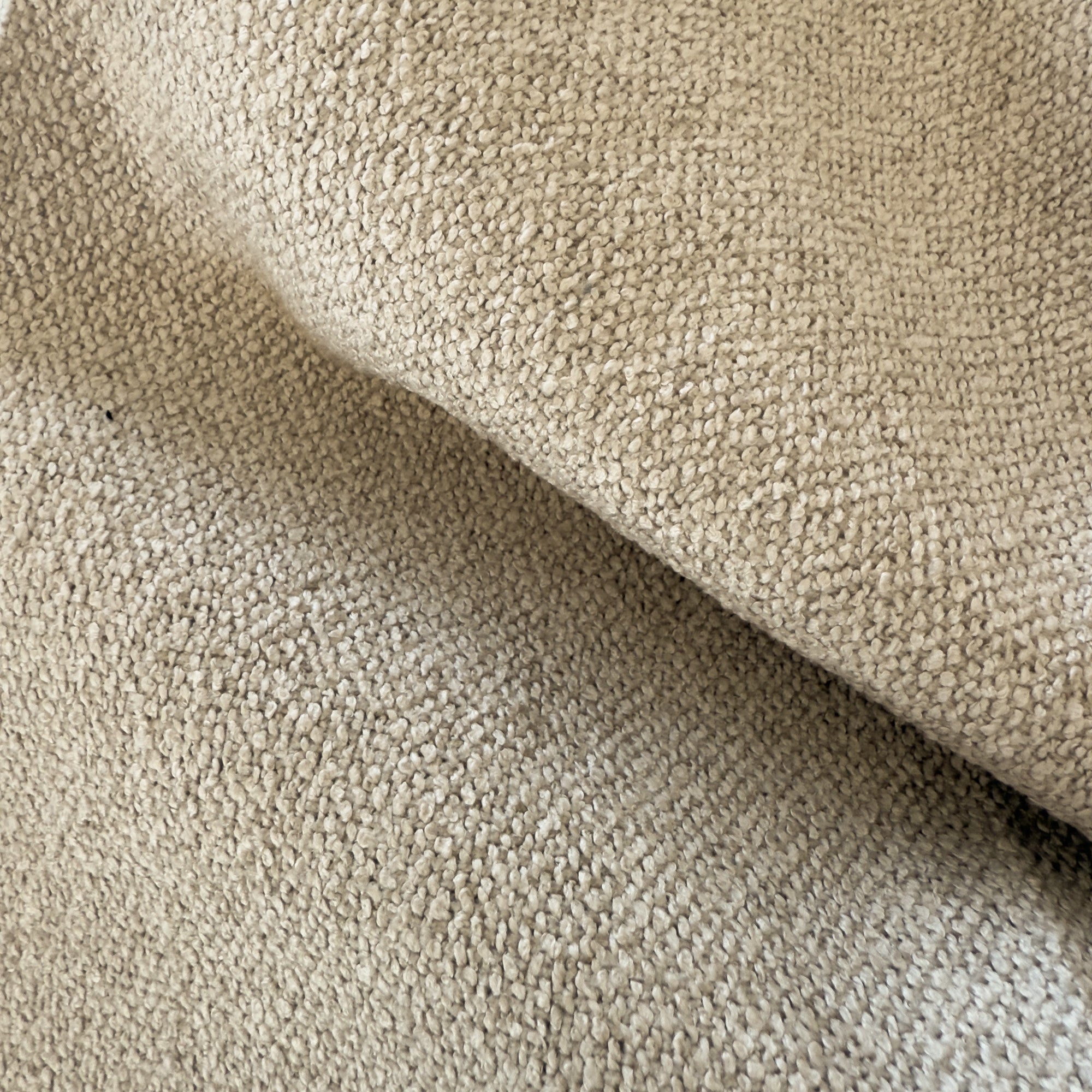 Primo piano del tessuto beige T33 Lambada di Divani.Store: una stoffa morbida, simile al cotone, fresca, accogliente, antimacchia e impermeabile, perfetta per rivestimenti o coperte in stile arredo moderno.