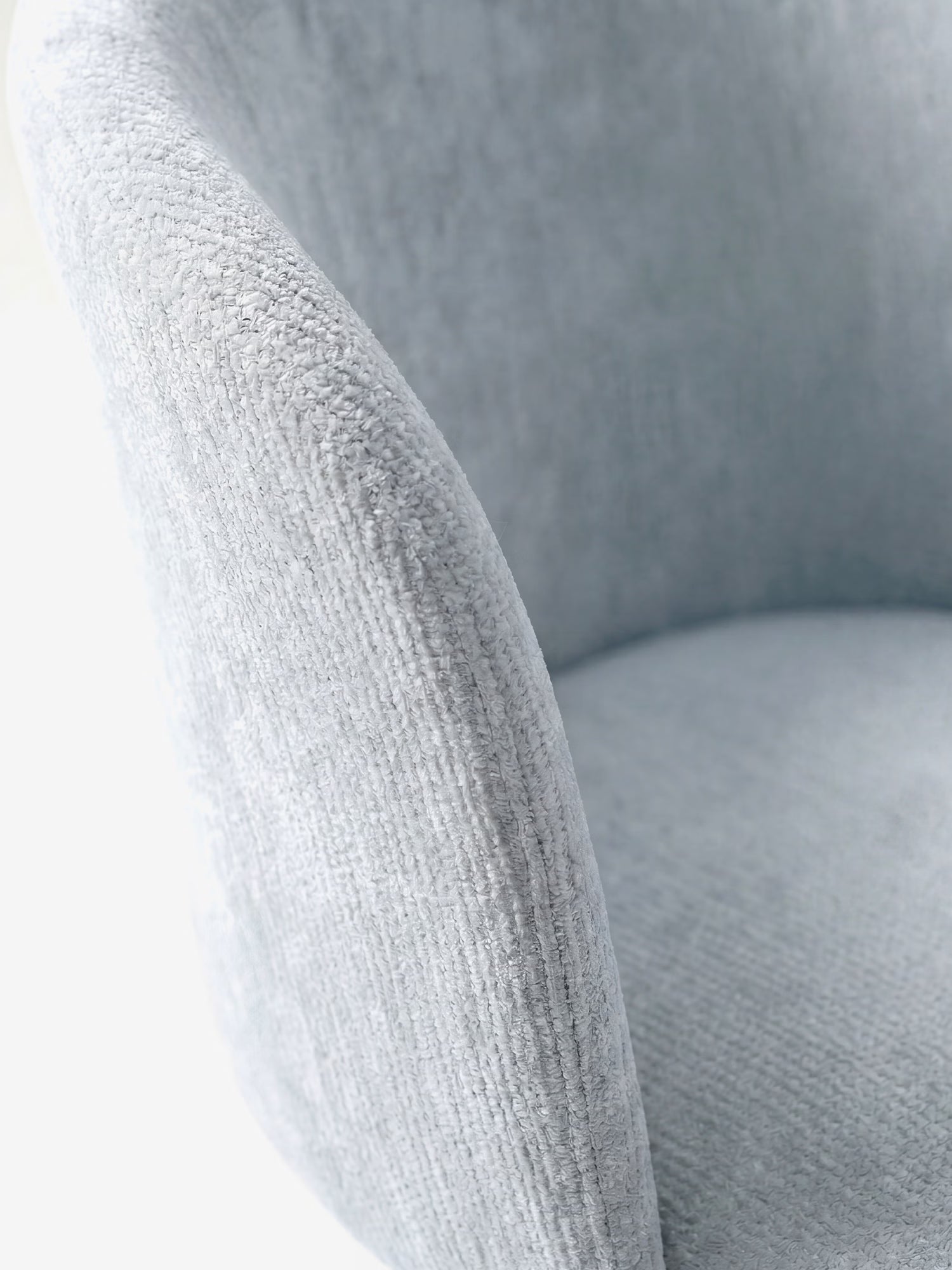 Primo piano della sedia moderna Talia di Divani.Store, rivestita in morbido tessuto ciniglia certificato OEKO-TEX® con base rivestita. L'immagine mette in risalto lo schienale curvo, la texture soffice e le linee eleganti su uno sfondo minimalista e luminoso.