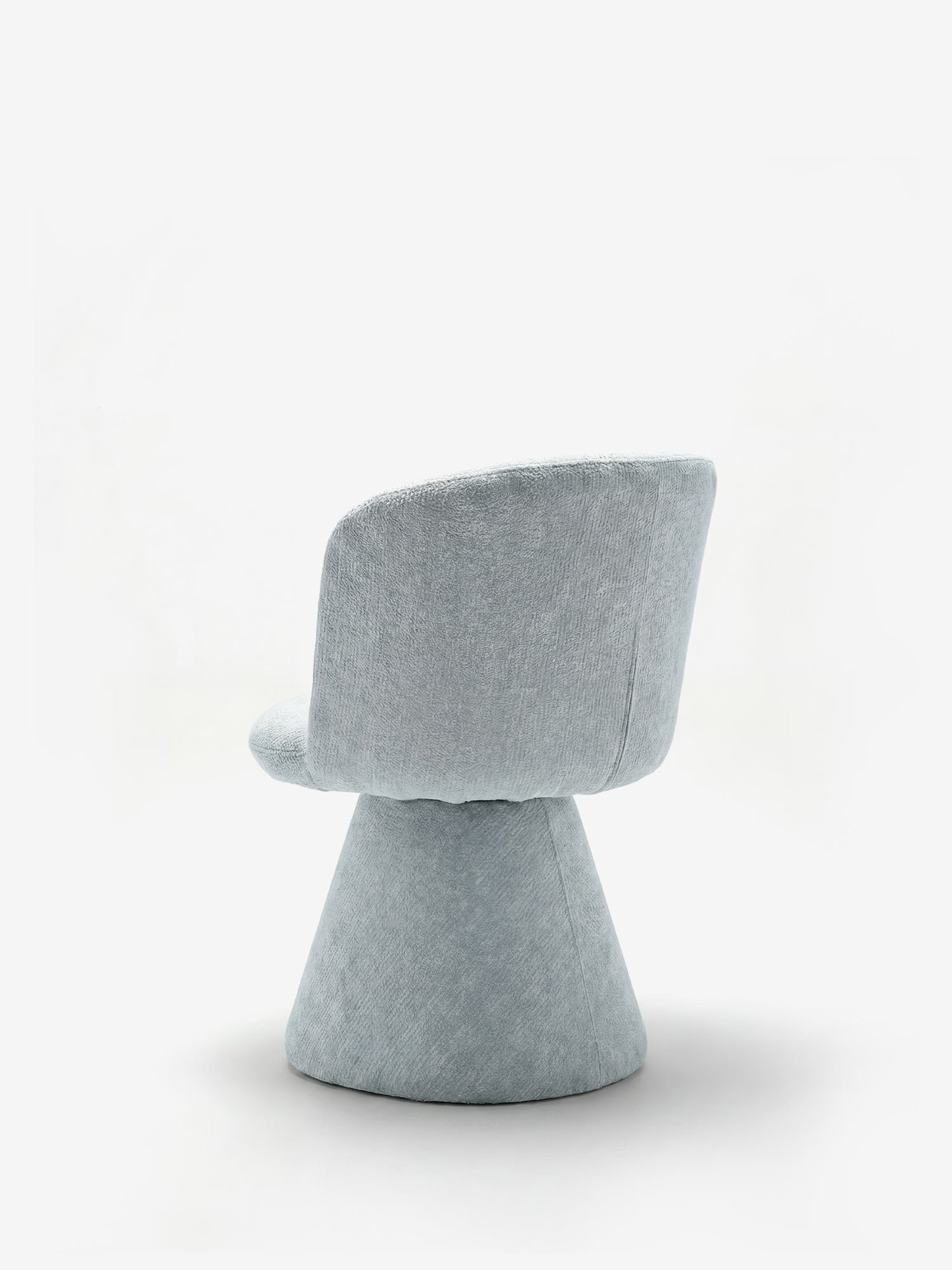 La sedia moderna imbottita Talia di Divani.Store, realizzata in morbido tessuto ciniglia OEKO-TEX® e con base rivestita, presenta schienale e seduta arrotondati su un’ampia base conica; è raffigurata su sfondo bianco, con vista laterale e posteriore.