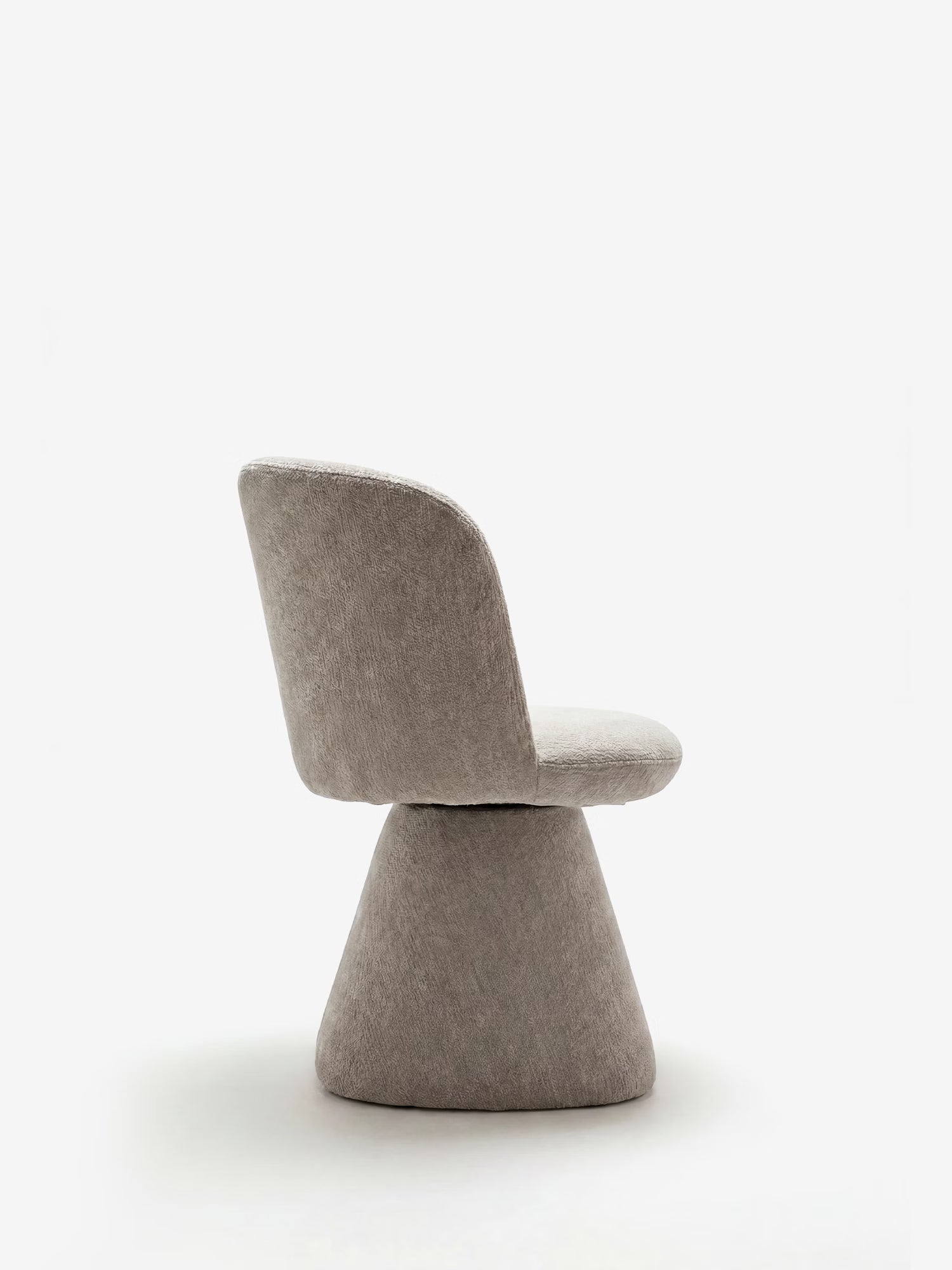 La sedia moderna imbottita Talia di Divani.Store presenta uno schienale e una seduta arrotondati in morbida ciniglia certificata OEKO-TEX®, con un'ampia base conica rivestita in tessuto. Ripresa di profilo, l'elegante sedia grigia risalta su uno sfondo bianco a tinta unita.