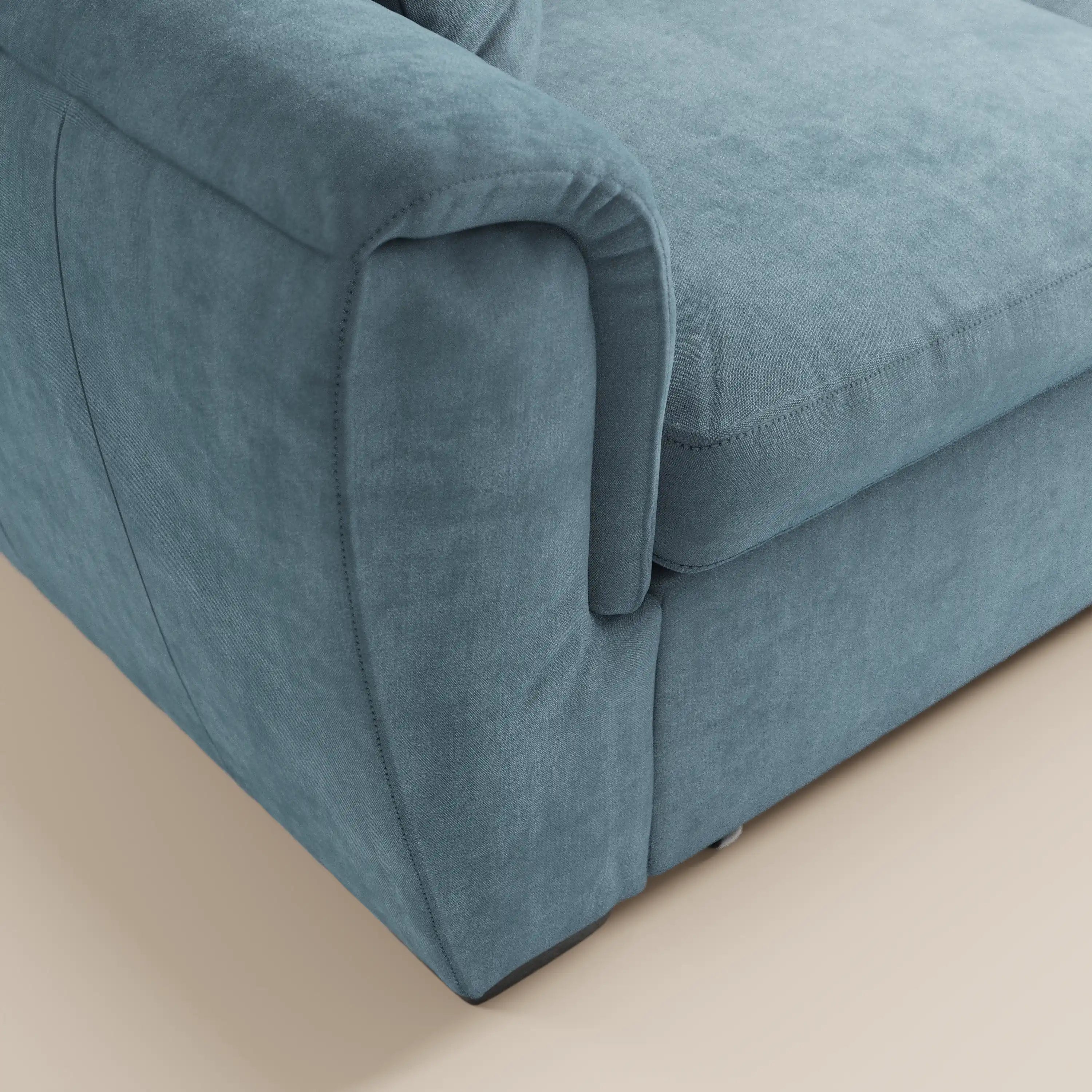 Primo piano del divano a 2 posti estraibile Titano di Divani.Store, caratterizzato da un tessuto lavabile Oeko-Tex® color verde acqua, poggiatesta reclinabili, cuciture a vista e un design compatto, perfetto per gli spazi moderni, su un pavimento chiaro e neutro.
