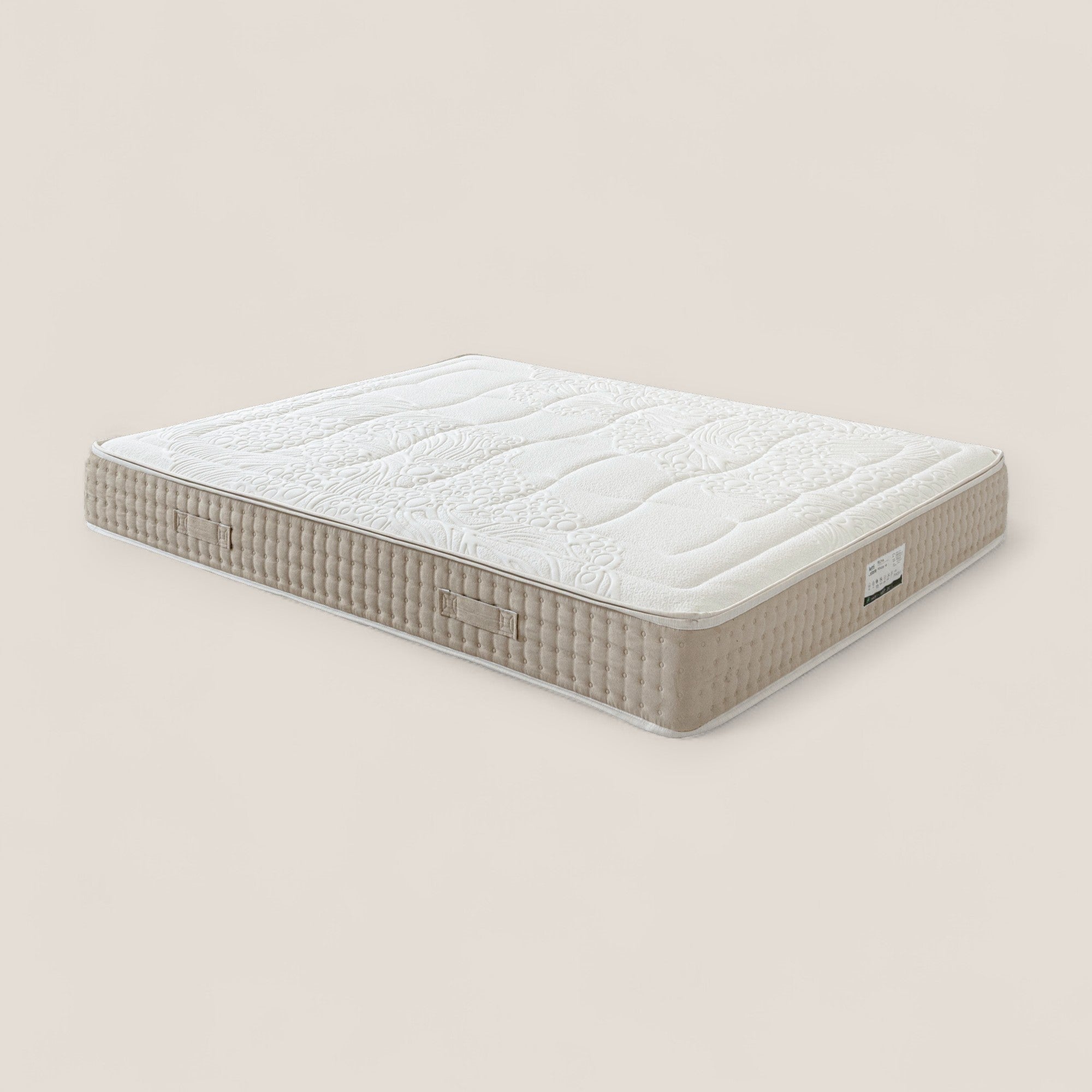 Il materasso VELTHA di Divani.Store è caratterizzato da un piano trapuntato beige e bianco, fianchi strutturati, micro-molle insacchettate per il comfort e lattice naturale a 7 zone. Due maniglie in tessuto si trovano su ogni lato; una targhetta rettangolare evidenzia l'angolo in basso a destra.