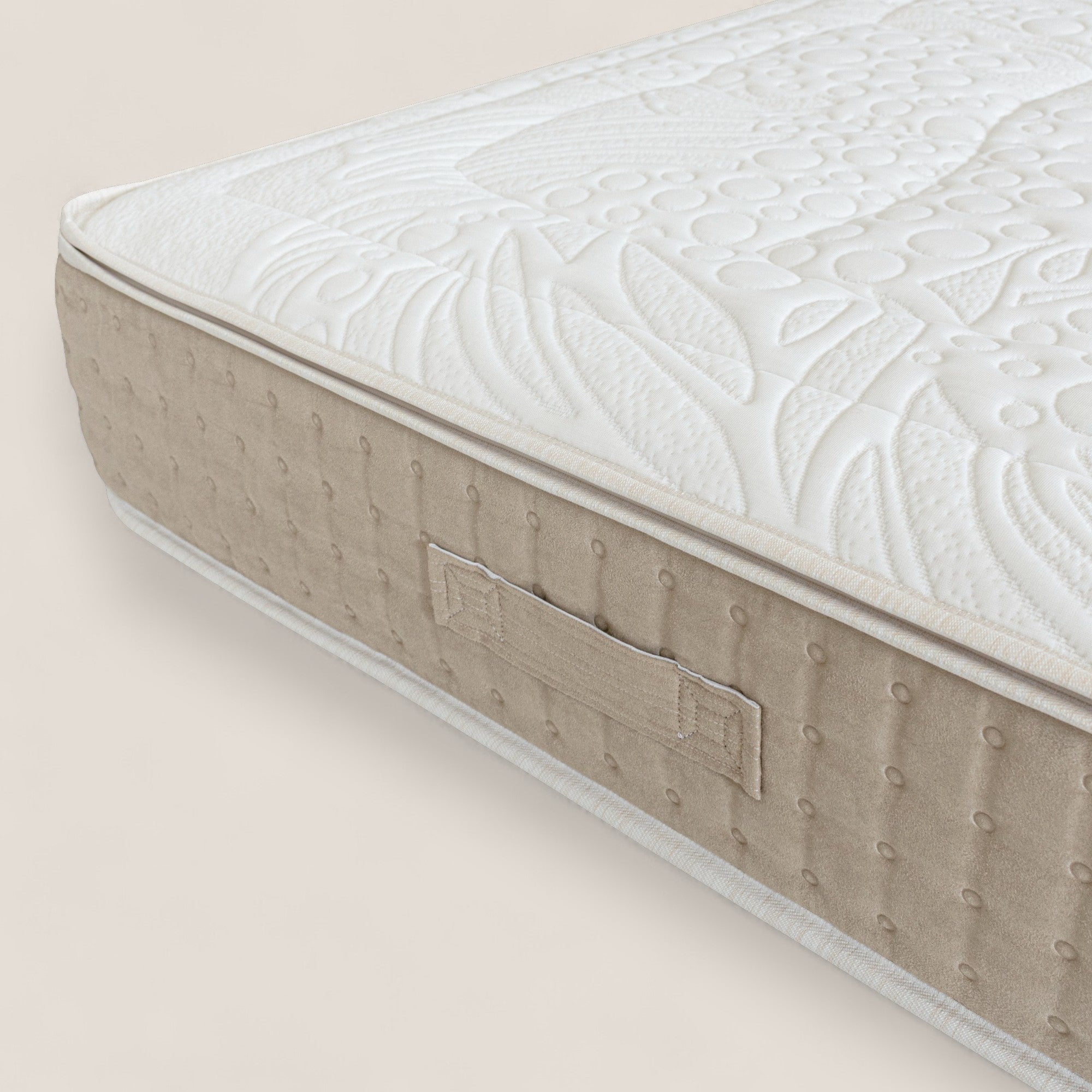 Un primo piano del VELTHA - Materasso Bio-Adattivo di Divani.Store con top bianco trapuntato, fianchi beige puntinati e maniglia. È dotato di molle insacchettate e di Lattice Naturale a 7 zone per un comfort ottimale.