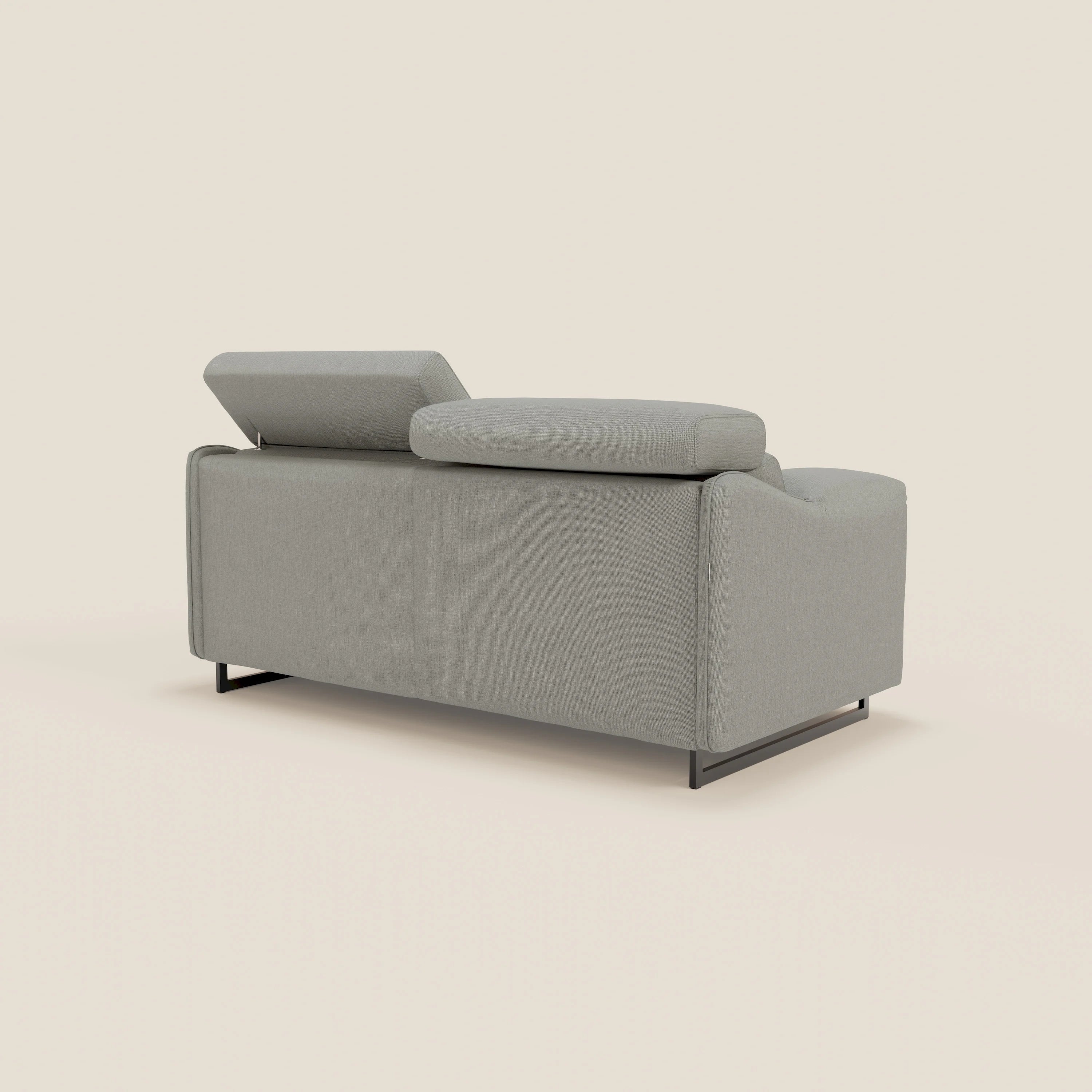 Un moderno divano letto Violetta da 197 cm di Divani.Store in impermeabile T13 grigio, visto dal retro, è caratterizzato da poggiatesta reclinabili (uno rialzato, uno piatto) e sottili gambe in metallo nero, su sfondo beige.