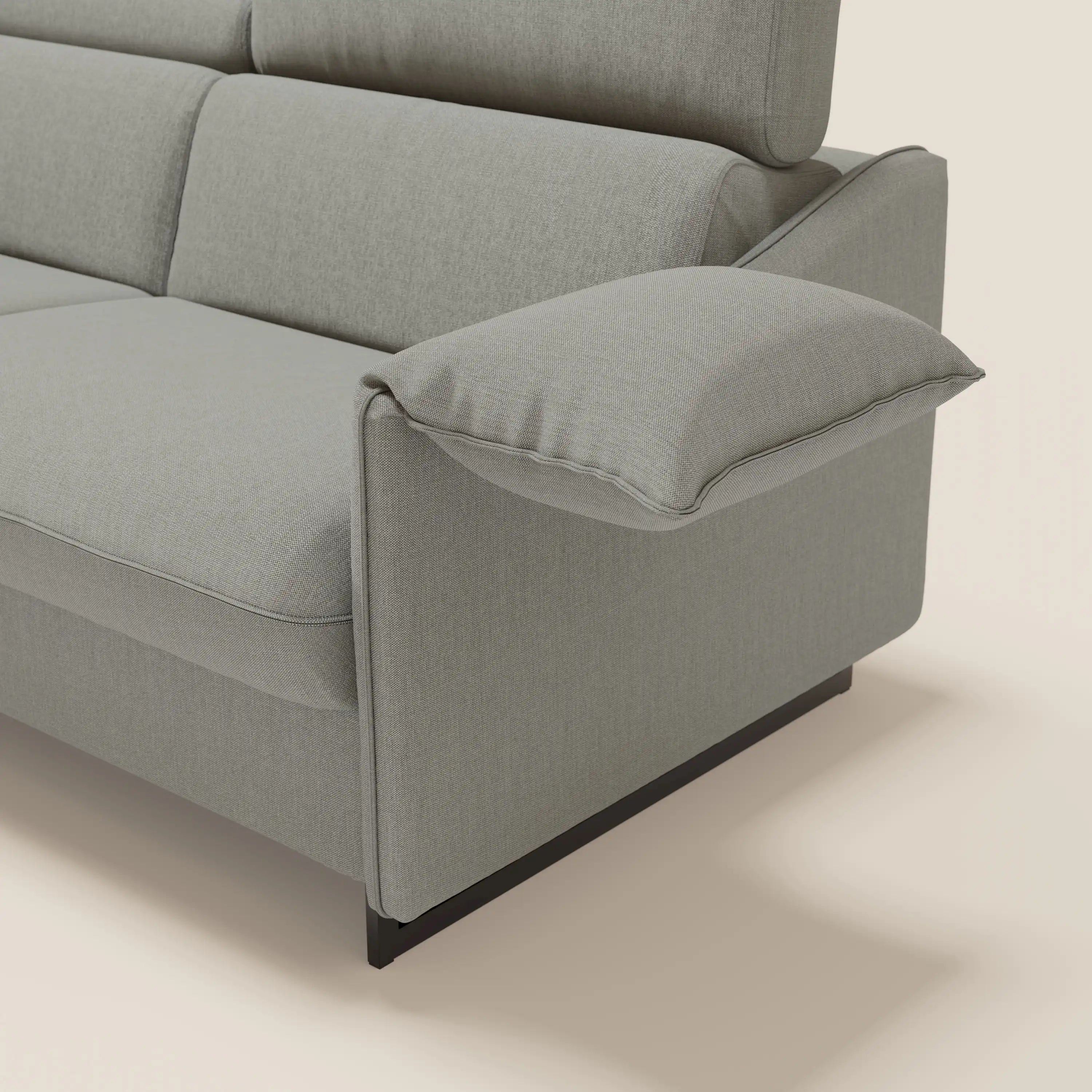 Un primo piano del divano letto Violetta 197 cm di Divani.Store mette in evidenza il tessuto impermeabile T13 GRIGIO, i braccioli mobili con cuscini in feltro, lo schienale a segmenti con poggiatesta reclinabili e le gambe in metallo nero su uno sfondo chiaro.