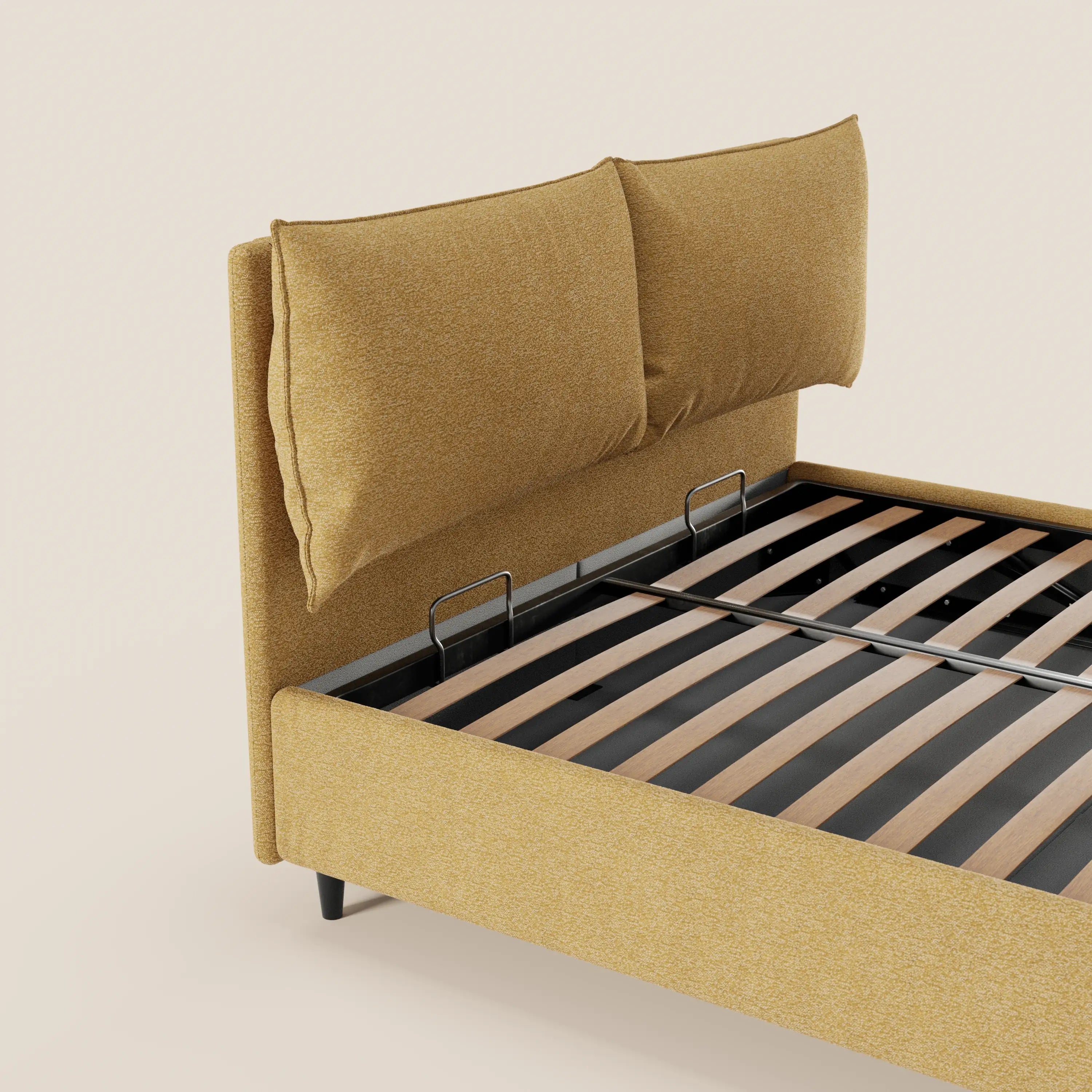 Il letto imbottito ZAYRON di Letti.store è realizzato in tessuto giallo senape certificato Oeko-Tex®, presenta due grandi cuscini regolabili sulla testiera, gambe nere, un vano contenitore e doghe in legno. Nella foto è raffigurato su uno sfondo beige chiaro a tinta unita.