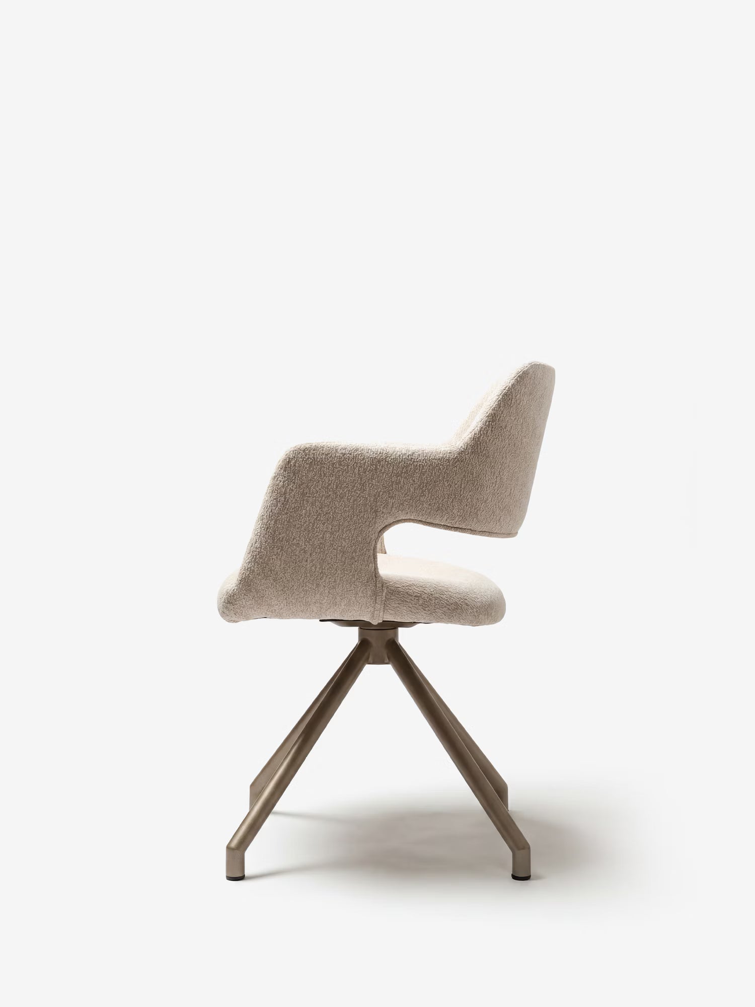 La sedia imbottita di design Zefira di Divani.Store è raffigurata di profilo con rivestimento in tessuto effetto cotone beige, braccioli, schienale curvo, spazio aperto tra seduta e schienale e gambe angolate in metallo color champagne, per un look moderno.