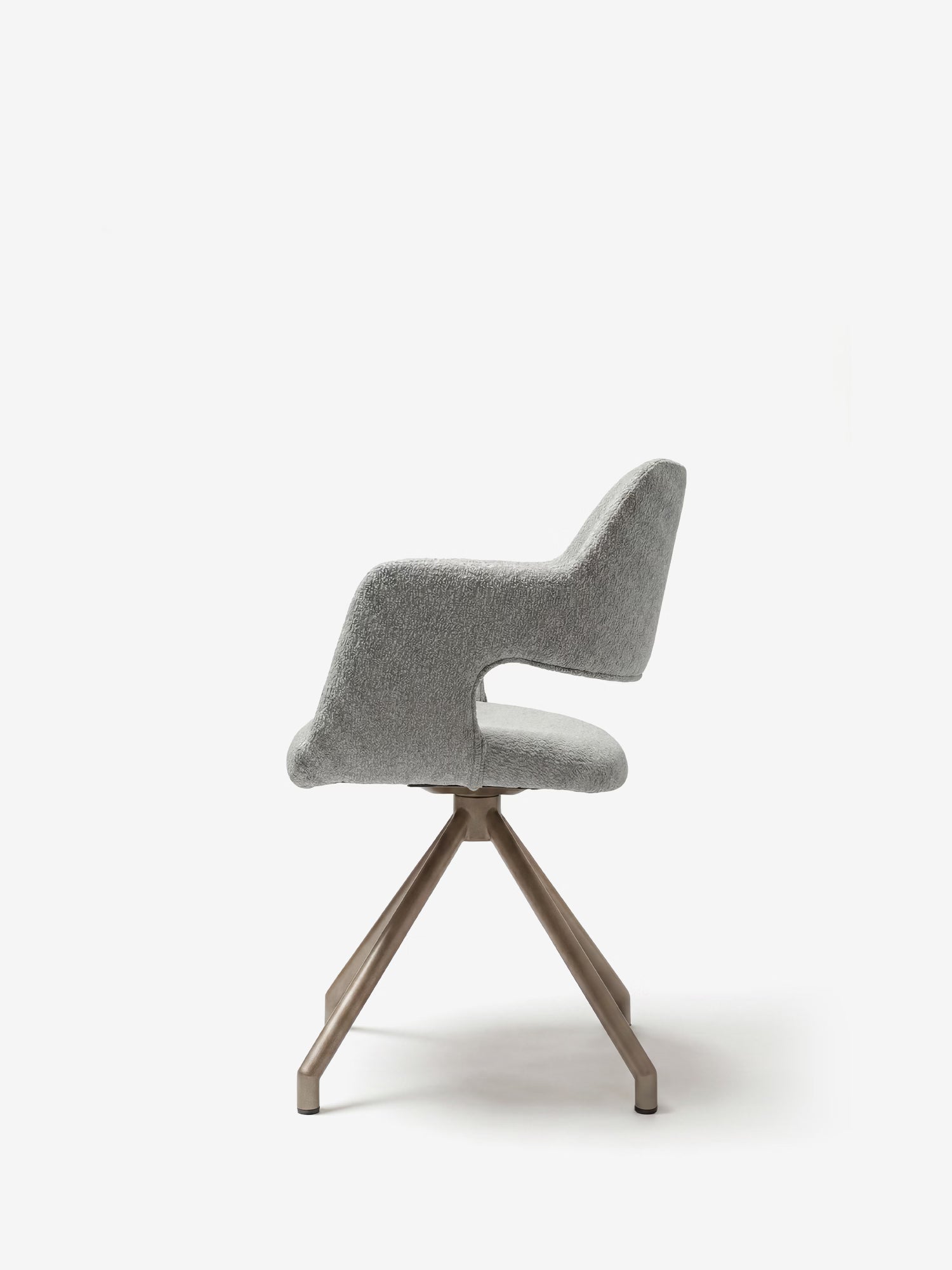 La sedia imbottita di design Zefira con braccioli di Divani.Store è realizzata in tessuto effetto cotone grigio chiaro e presenta una base in metallo color champagne; nella foto è ritratta di profilo su uno sfondo bianco a tinta unita, con lo schienale moderno e curvo e i braccioli ben visibili.