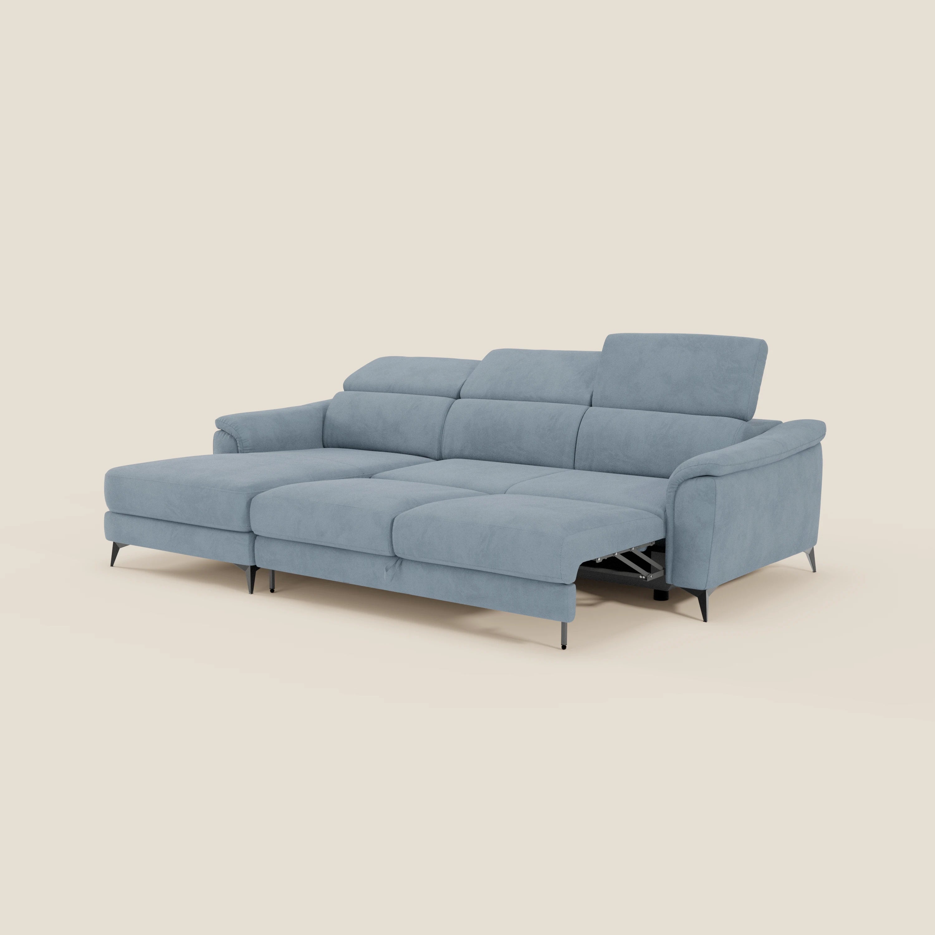 Arcos Divano con penisola di Divani.Store è caratterizzato da piedini alti, poggiatesta reclinabili, seduta estraibile e poggiapiedi parzialmente estensibile in T11 carta da zucchero microfibra, su sfondo beige tinta unita.