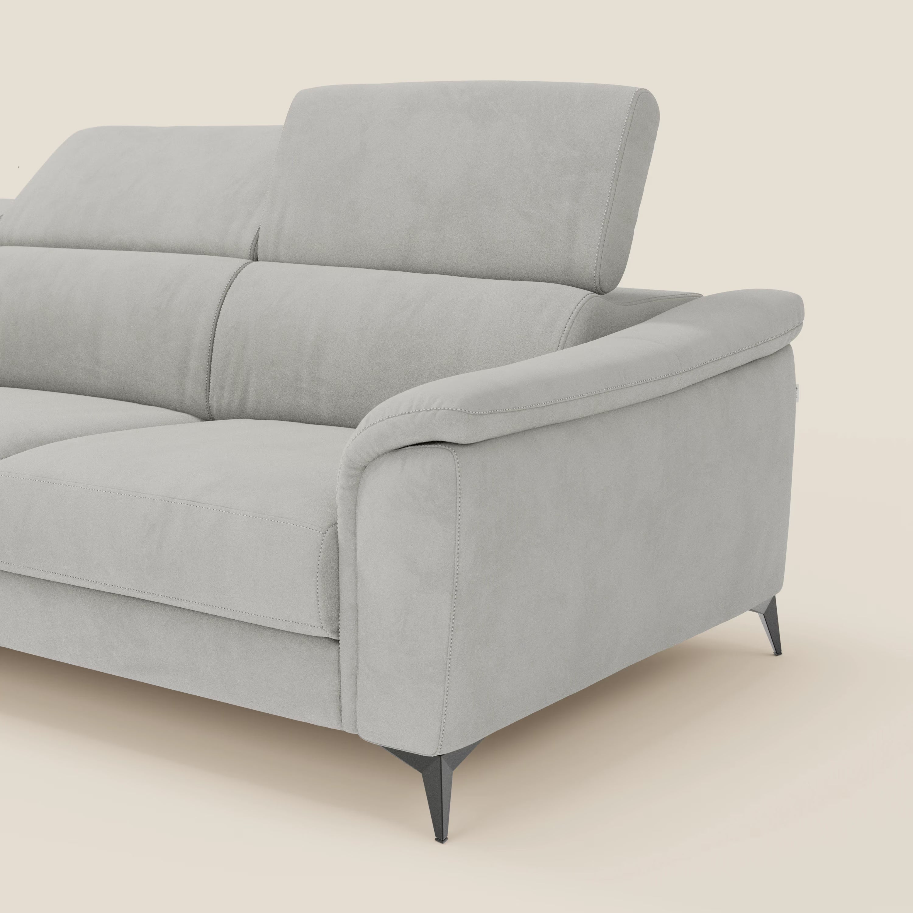 Arcos Divano con penisola di Divani.Store è caratterizzato da microfibra impermeabile grigio chiaro T11, gambe alte, ampi braccioli imbottiti, dettagli di cucitura e schienale parzialmente rialzato con poggiatesta regolabile. Lo stile moderno si adatta a un ambiente color crema chiaro.