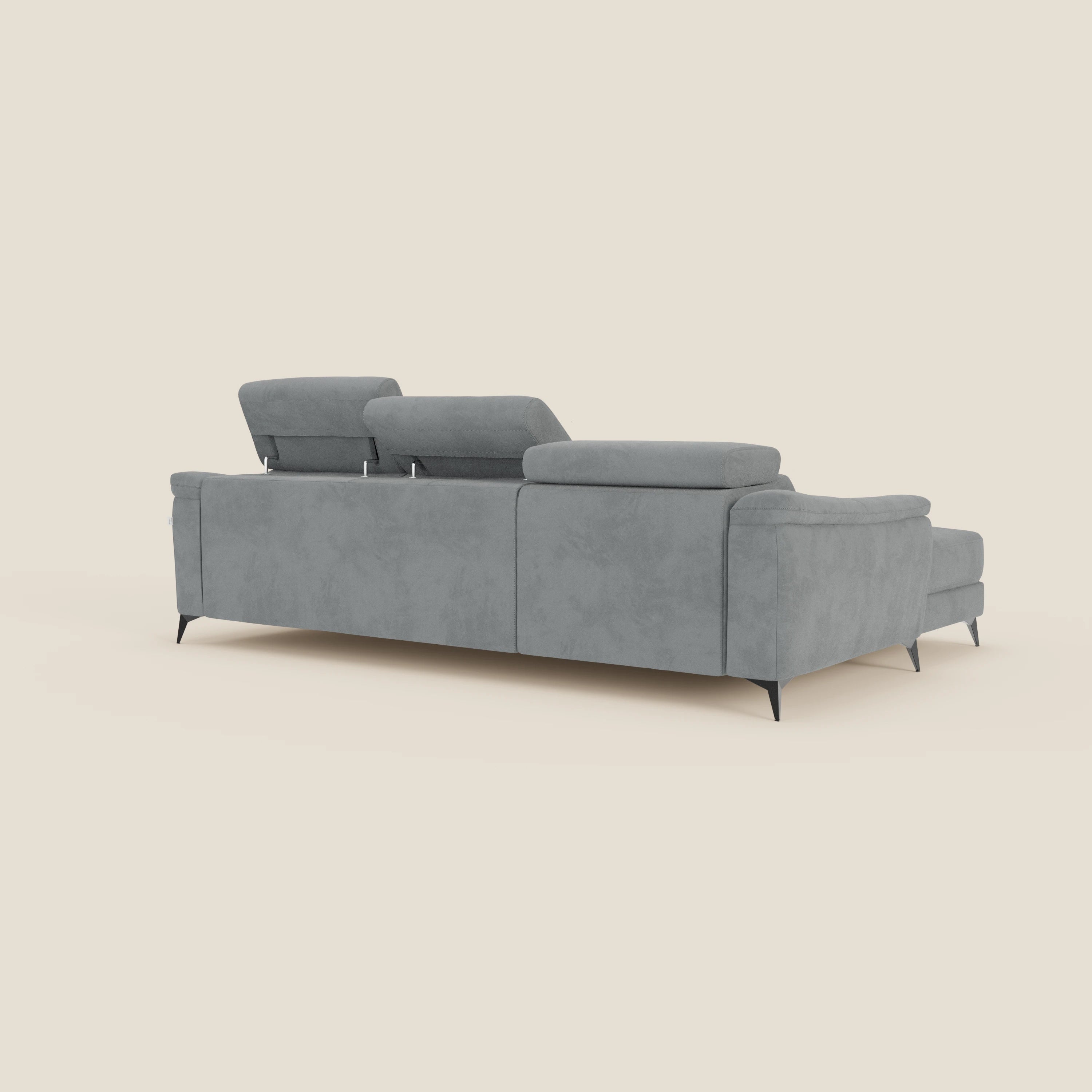 L'Arcos Divano con penisola di Divani.Store, in microfibra impermeabile T11 grigio, è caratterizzato da piedini alti neri, poggiatesta reclinabili e cuscini morbidi. Mostrato dal retro su un semplice sfondo bianco sporco.