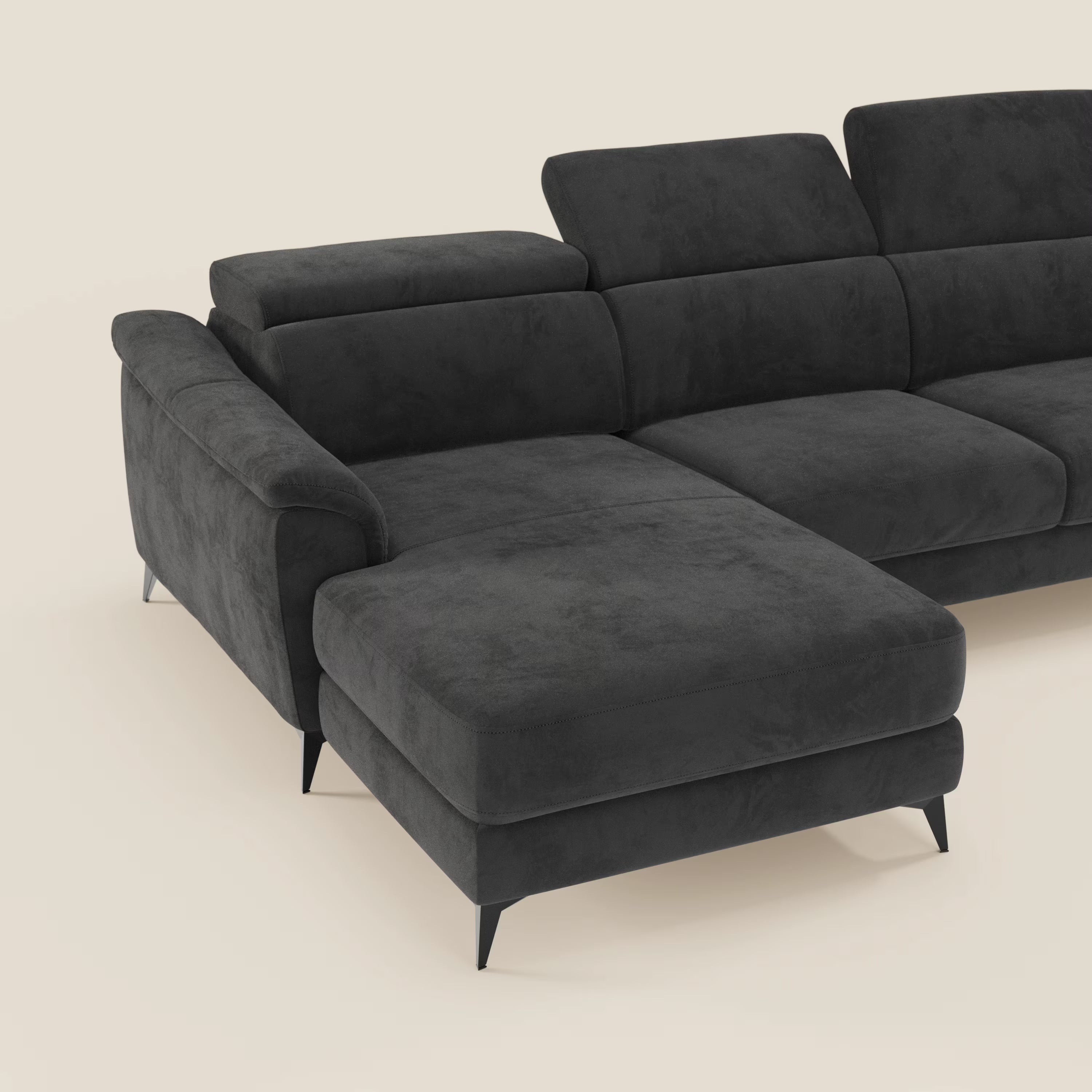 L'Arcos Divano con penisola di Divani.Store è caratterizzato da microfibra nera impermeabile T11, ampie sedute, gambe alte, poggiatesta reclinabili e prolunga della chaise longue sul lato sinistro, che mettono in mostra l'artigianalità italiana su uno sfondo chiaro.