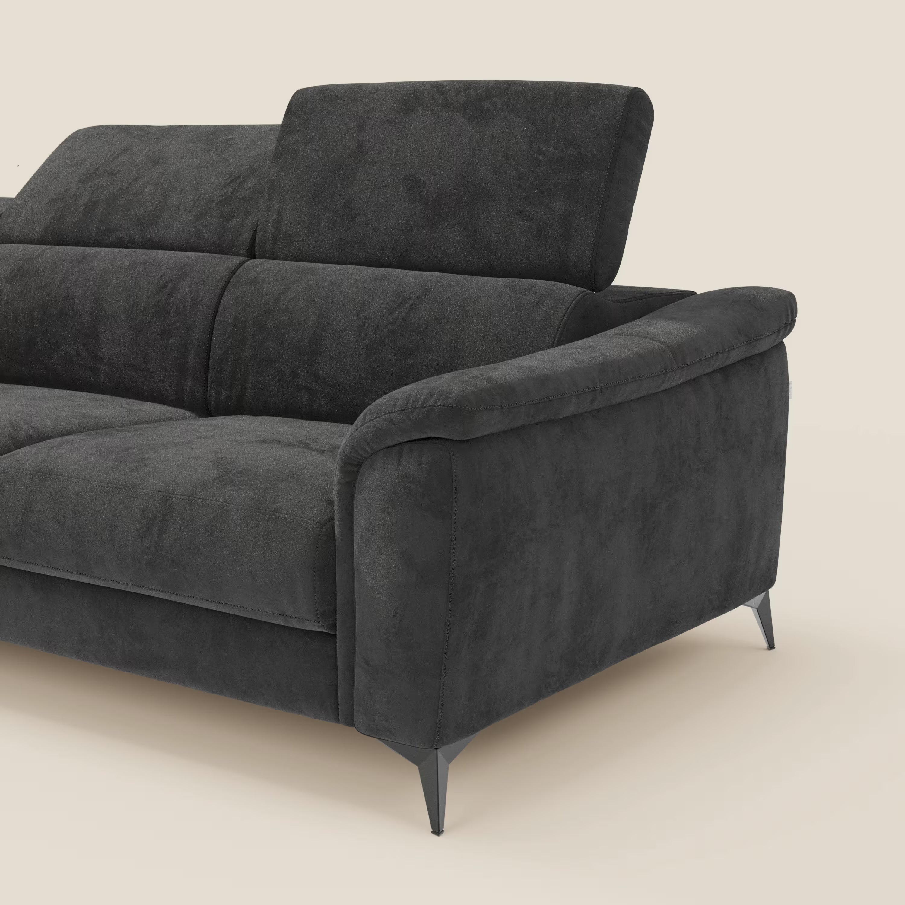 Arcos Divano con penisola di Divani.Store è caratterizzato da alte gambe in metallo, poggiatesta regolabili e rivestimento in microfibra impermeabile nera T11, che mette in mostra la raffinata artigianalità italiana su uno sfondo beige chiaro.